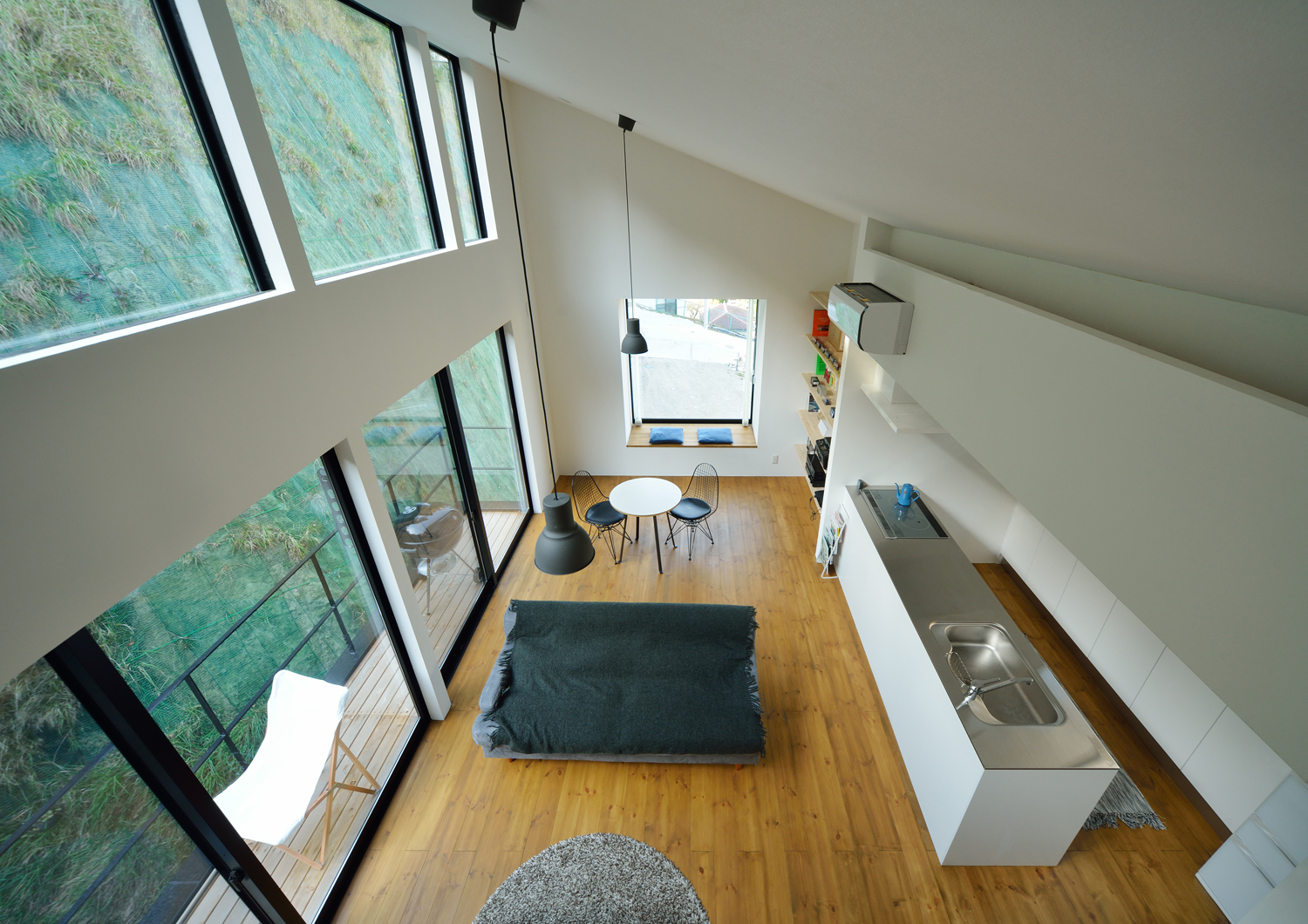 天井近くまで窓がある斜め屋根の吹き抜けのLDK・デザイン住宅