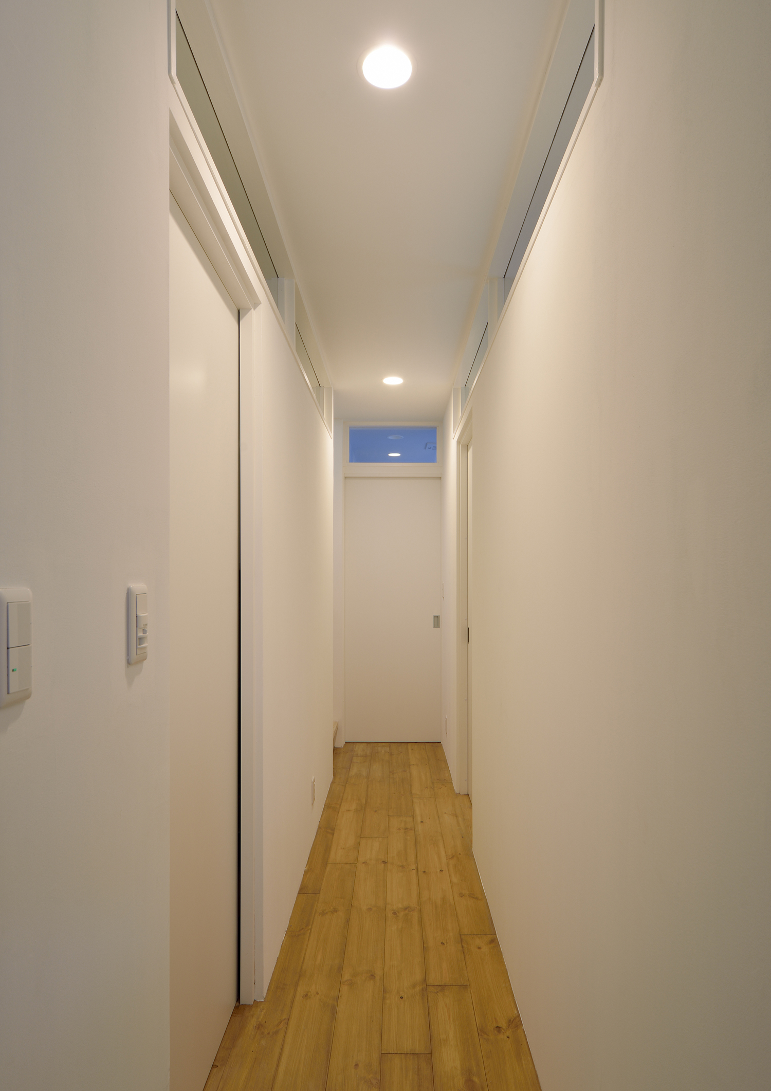 ダウンライトが取り付けられた白い壁の廊下・デザイン住宅