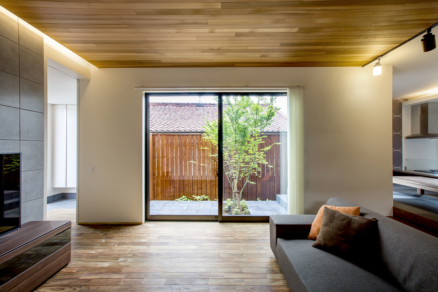 中庭に面した窓がある木目の天井のおしゃれなLDK・デザイン住宅