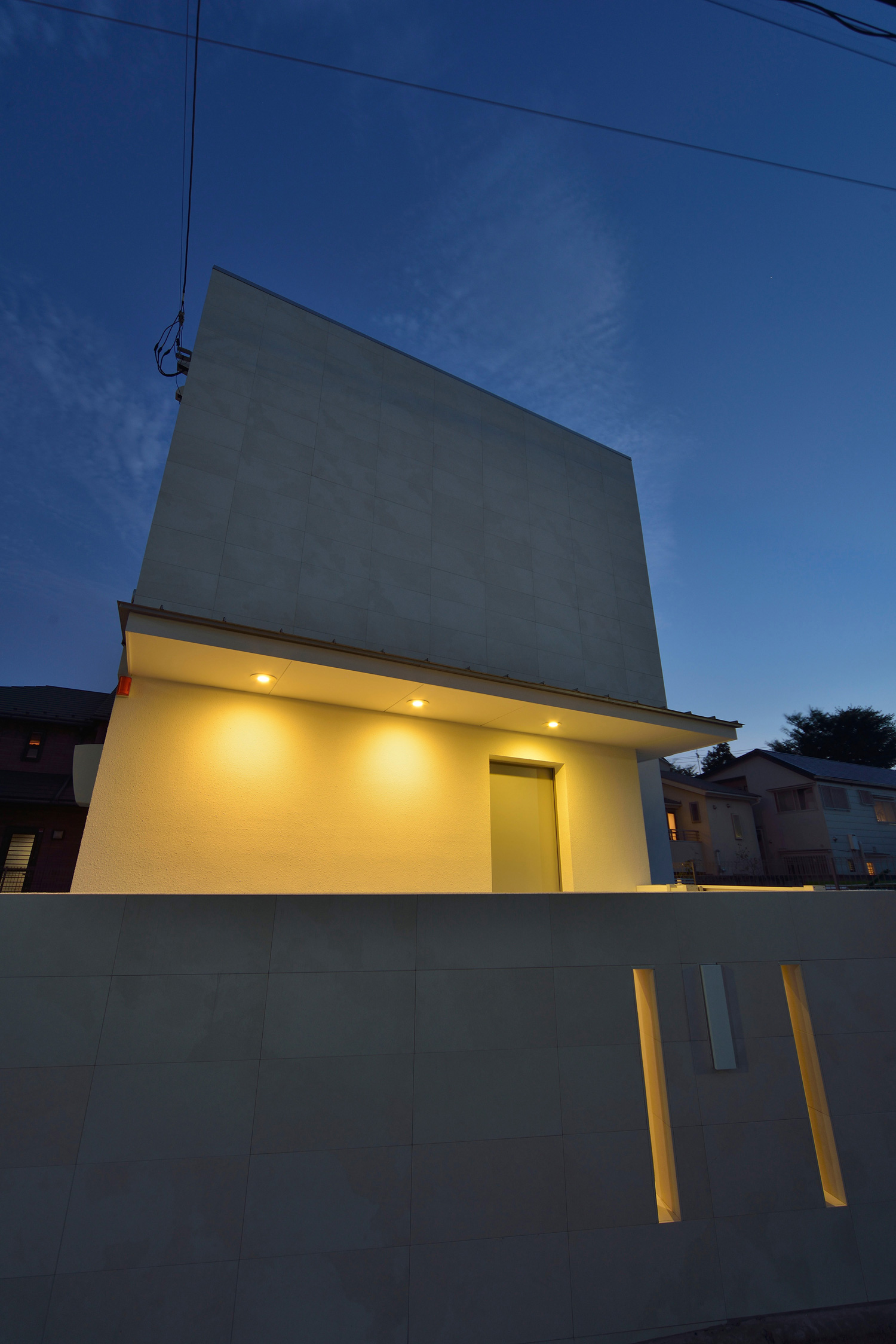 間接照明付きの屋根があるシンプルなコンクリートの外壁の家・デザイン住宅