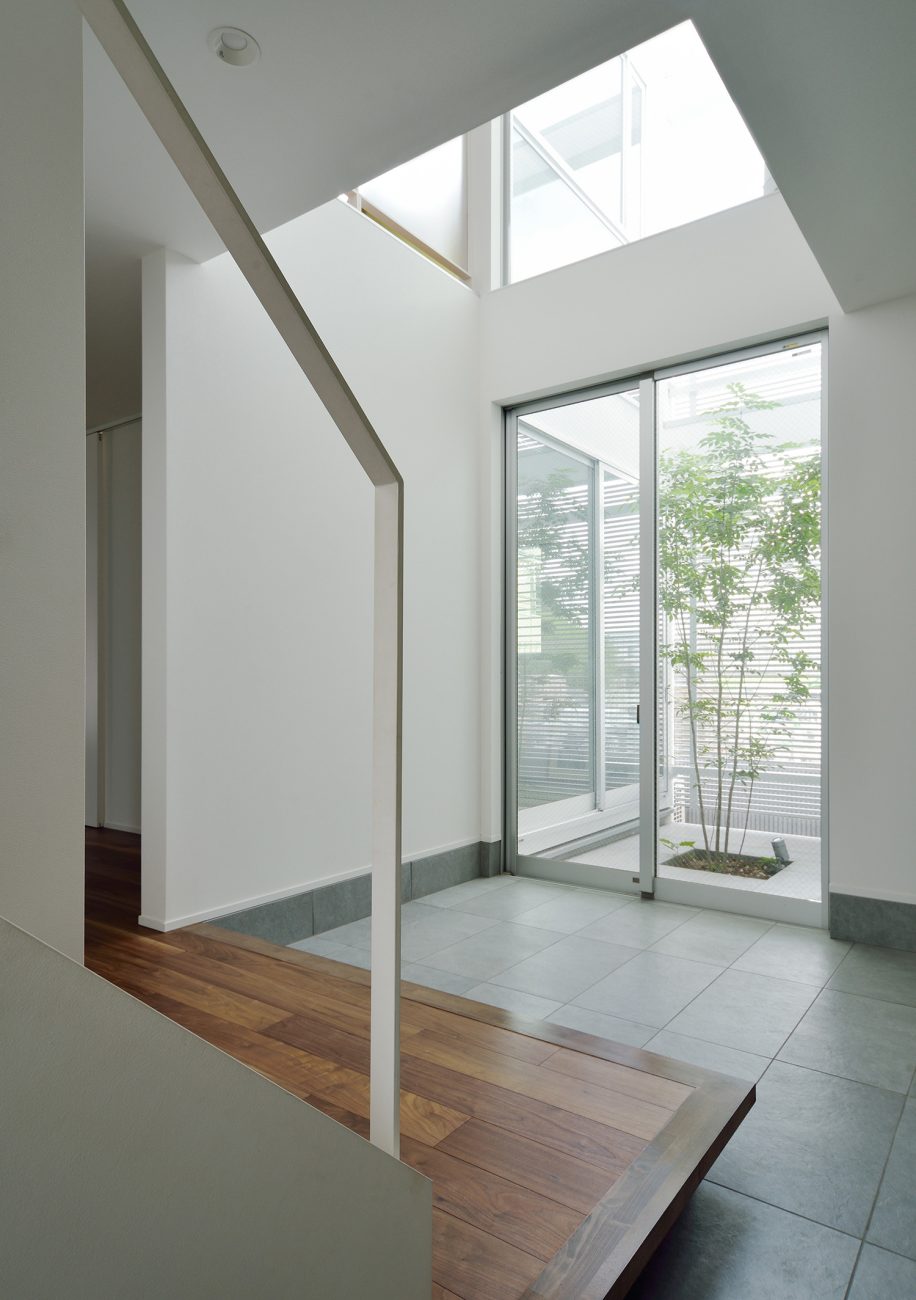 中庭に面した窓がある吹き抜けのある開放的な玄関・デザイン住宅