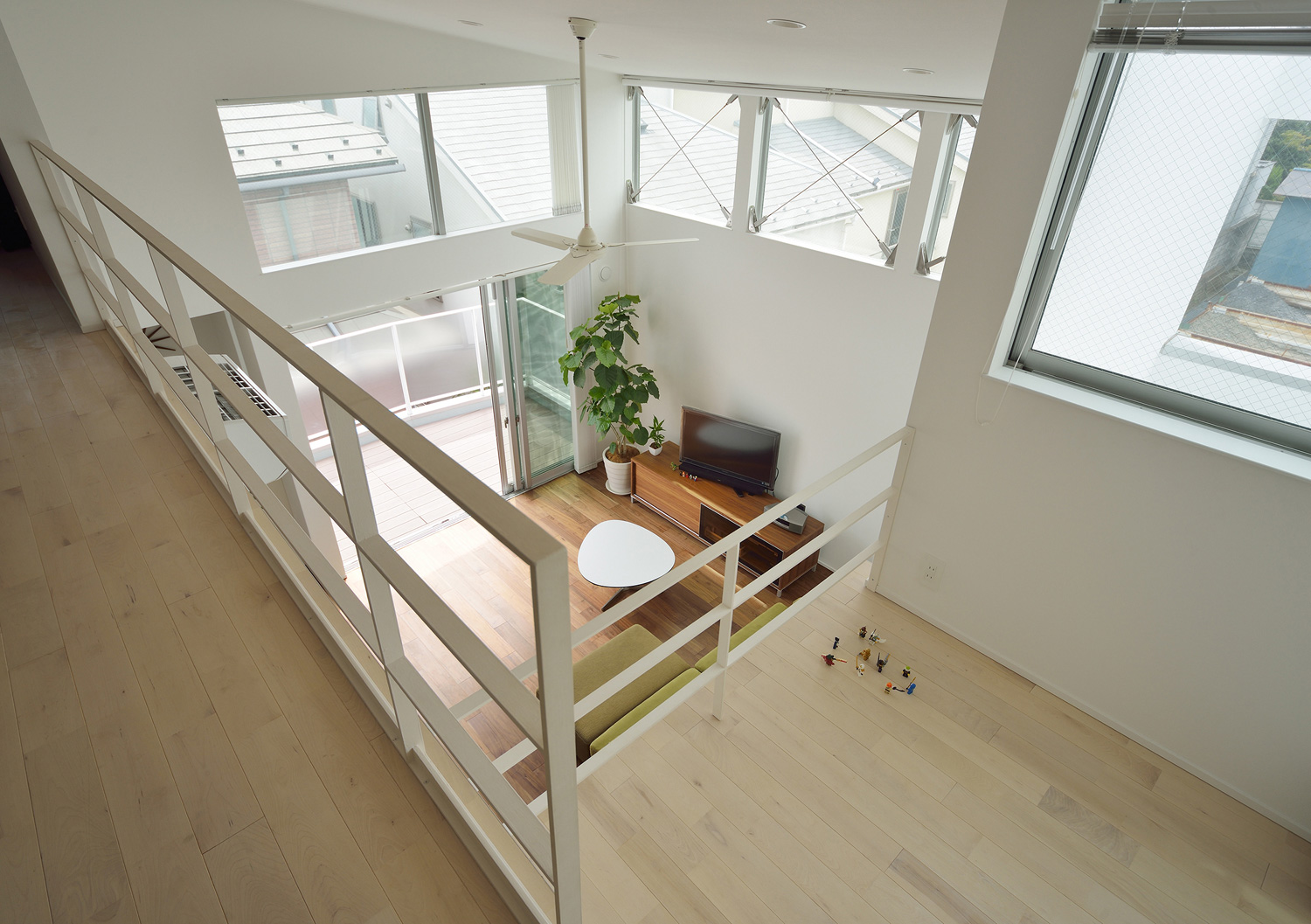 吹き抜けに面したロフトからLDKを見下ろした様子・デザイン住宅