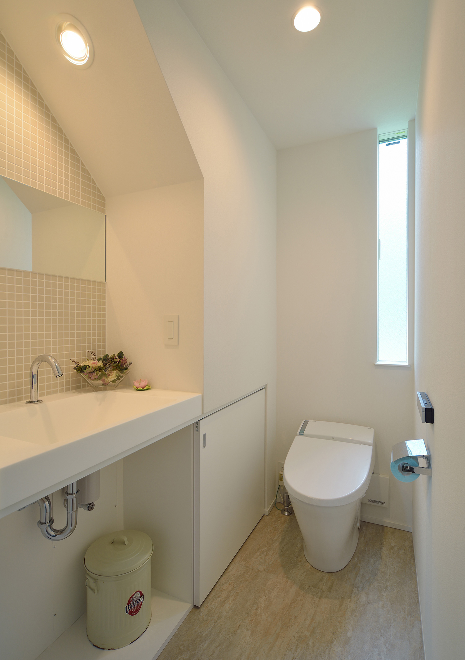 手洗いカウンターが取り付けられた広いトイレ・デザイン住宅