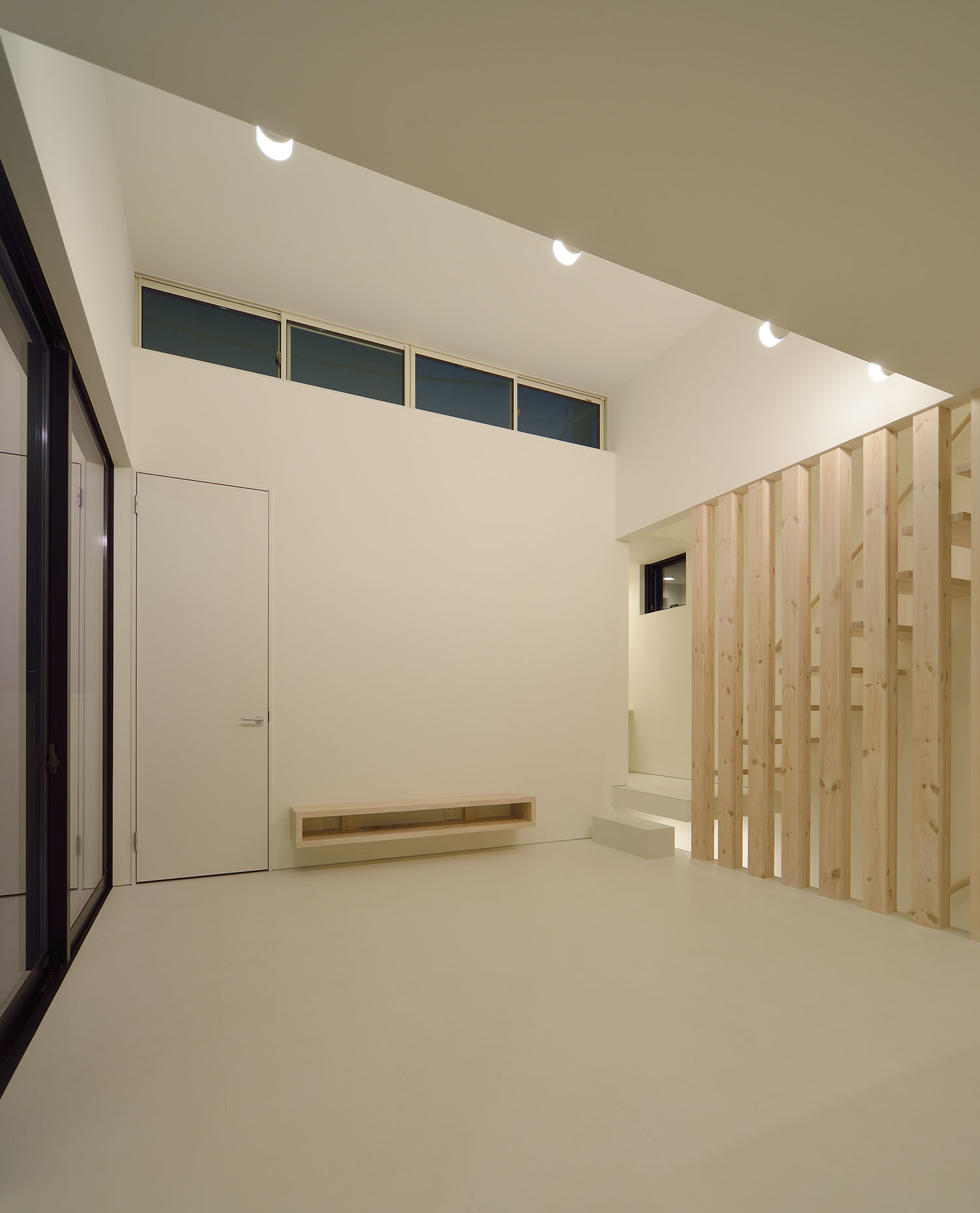 壁に間接照明が取り付けられた高天井のシンプルなLDK・デザイン住宅