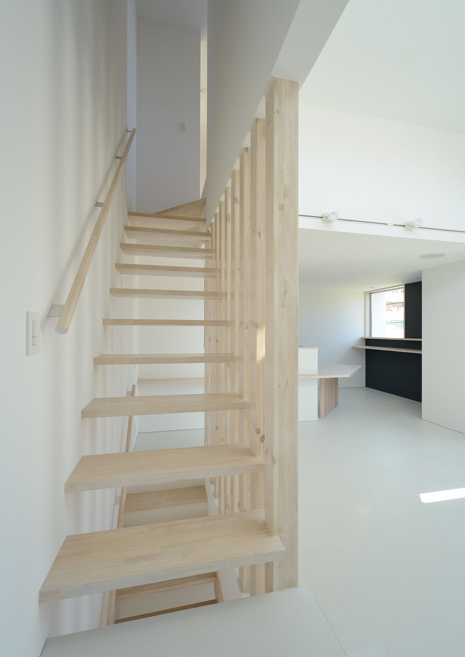 色の薄い木材を使ったスケルトン階段とルーバーの壁・デザイン住宅