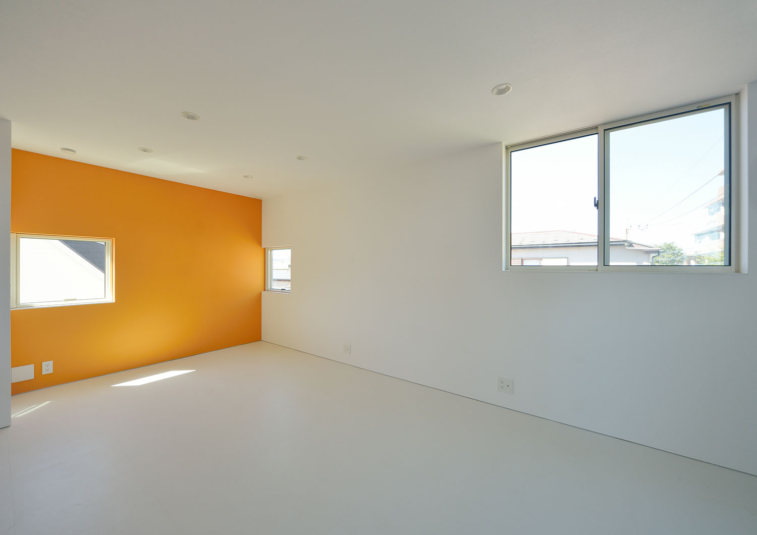 オレンジのアクセントクロスがあるシンプルな個室・デザイン住宅