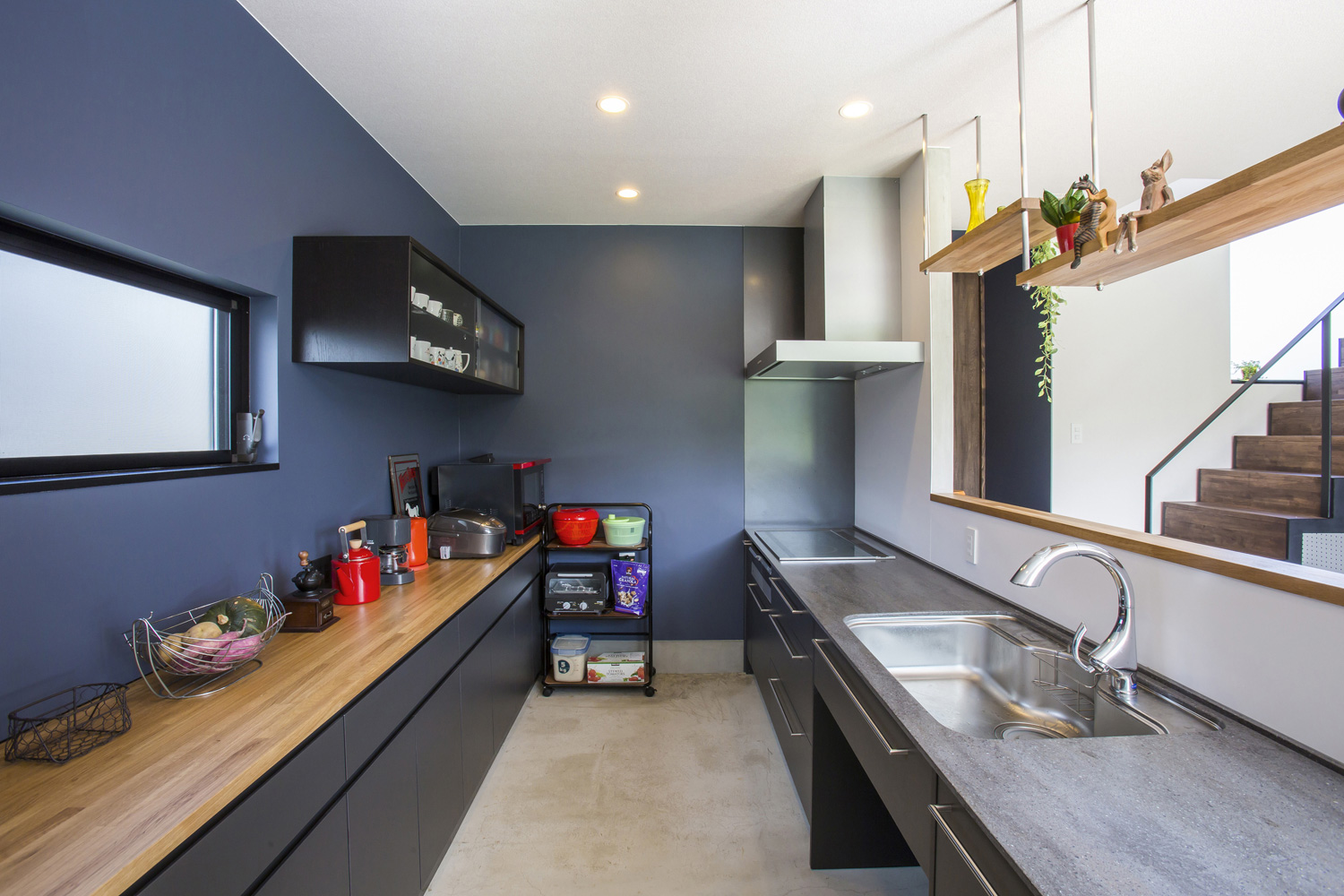 青い壁のカップボードがある半個室のキッチン・デザイン住宅