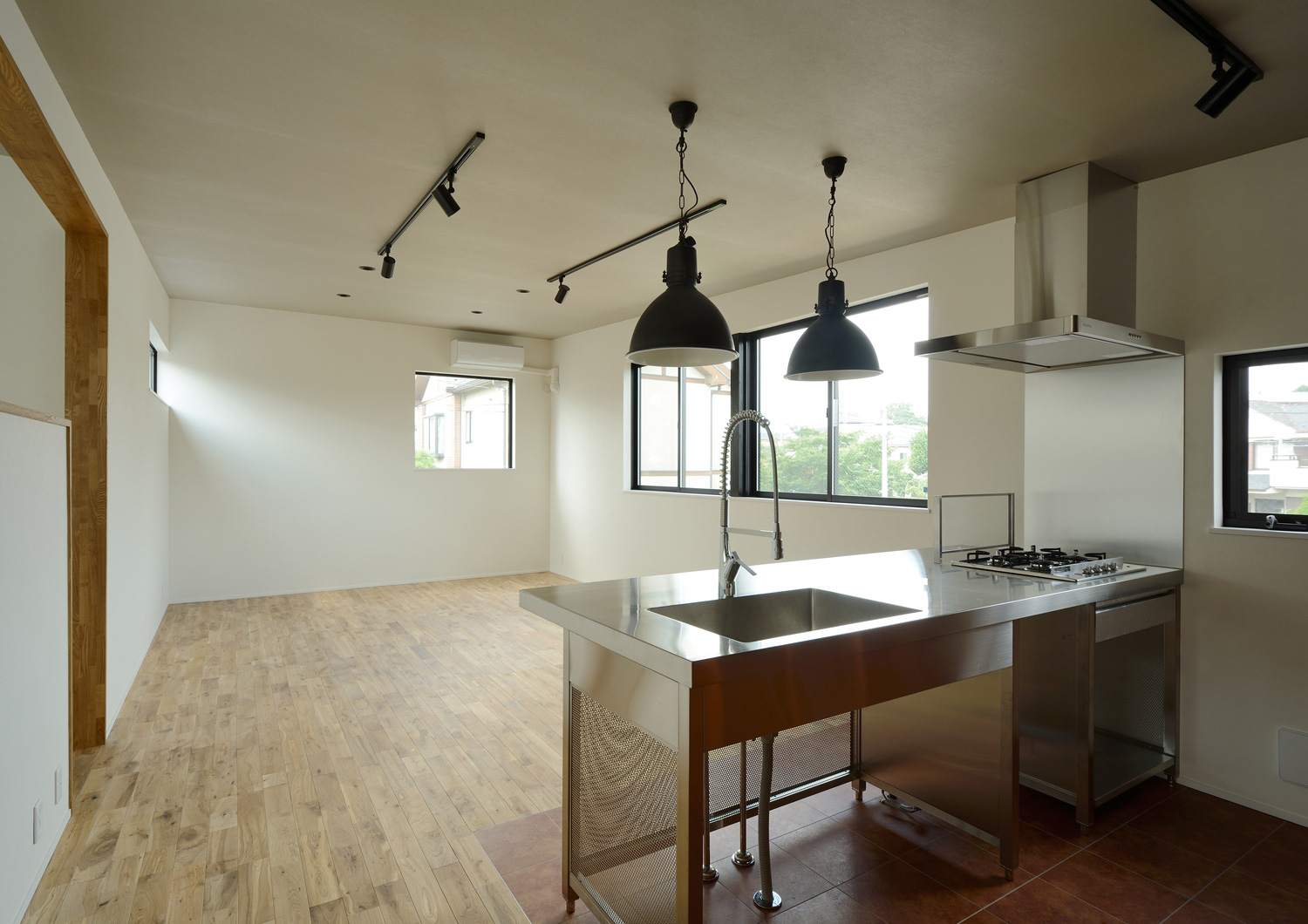 ステンレスのペニンシュラキッチンがあるシンプルなLDK・デザイン住宅