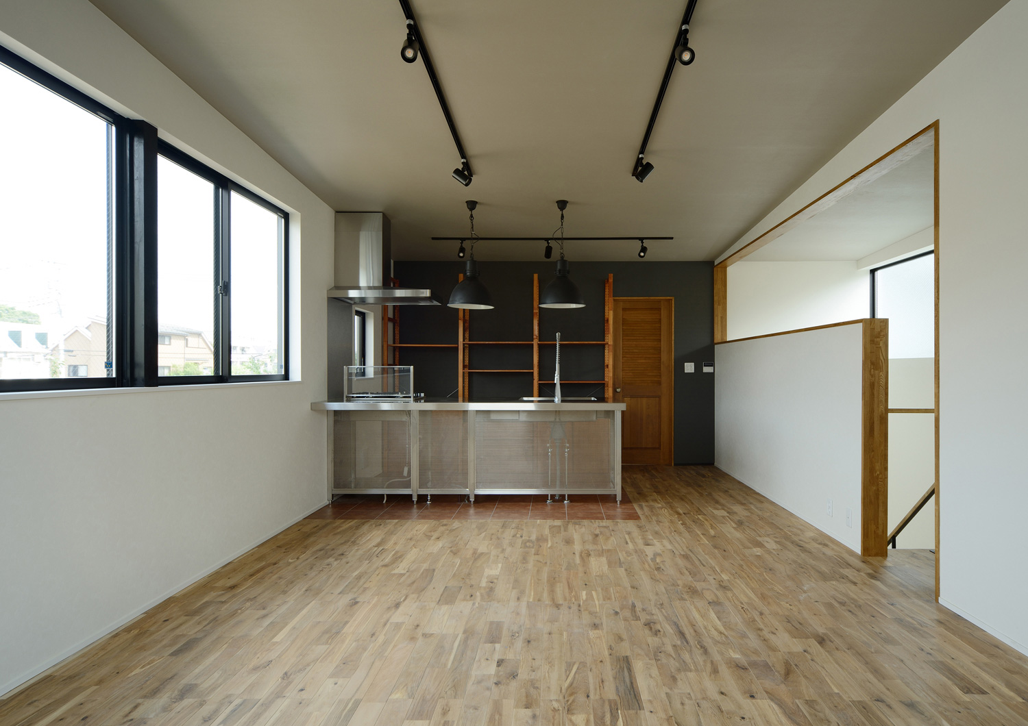 天井にライトレールを取り付けたステンレスのキッチンがあるシンプルなLDK・デザイン住宅