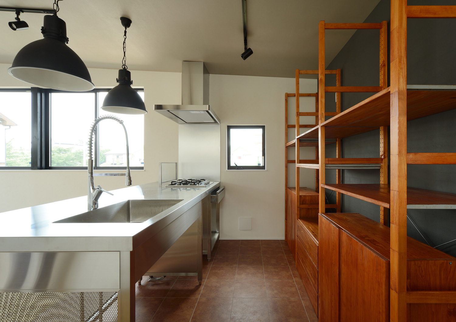 アクセントウォールに木の棚を取り付けた造作カップボードがあるキッチン・デザイン住宅