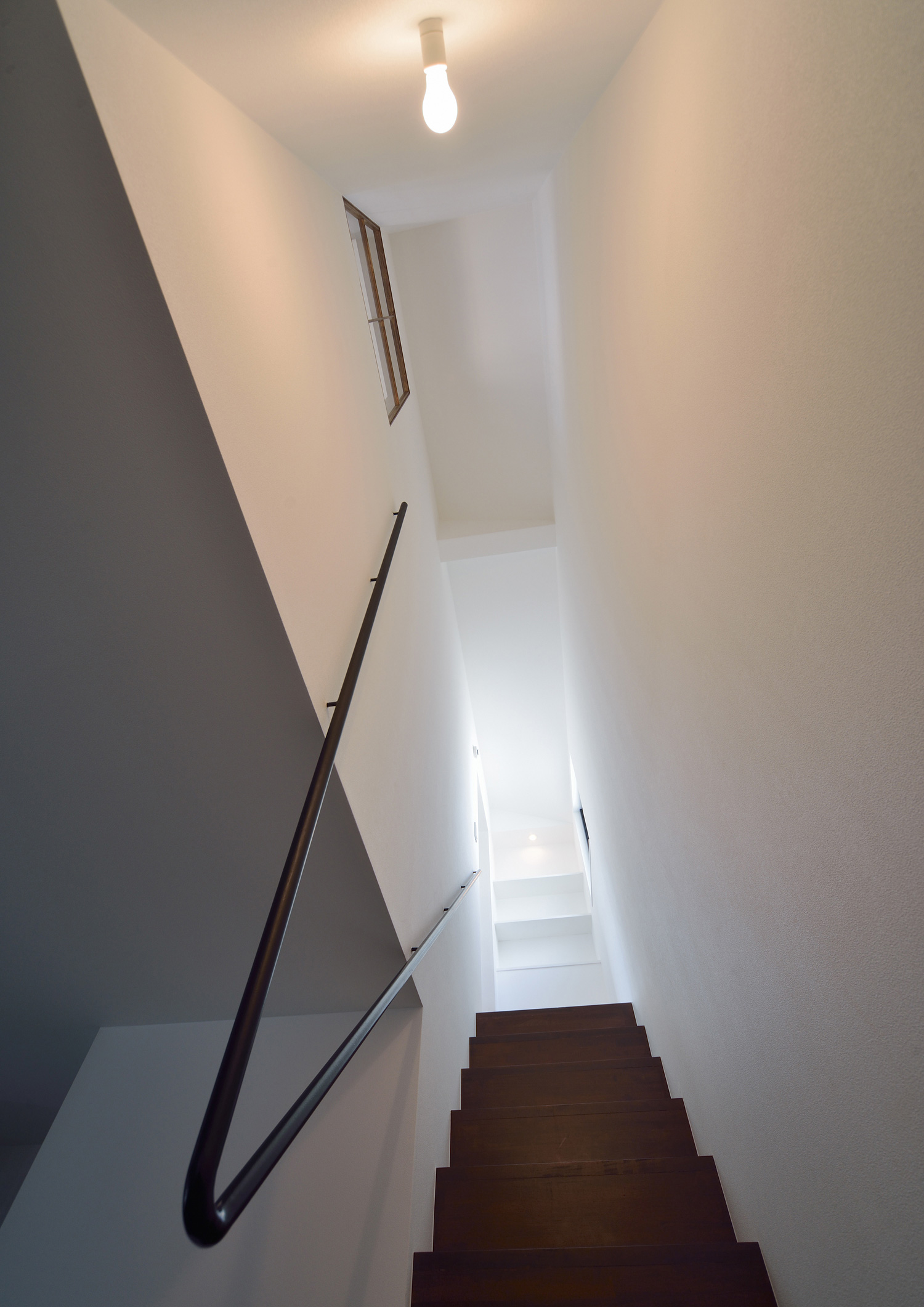 シンプルなアイアンの手すりが取り付けられた木製の箱型階段・デザイン住宅