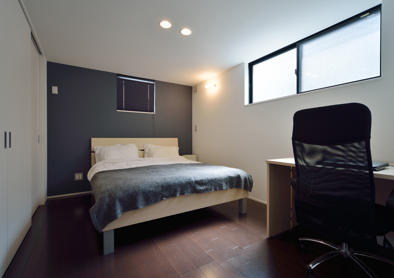 ベッドとデスクがあるシンプルで落ち着きのある寝室・デザイン住宅
