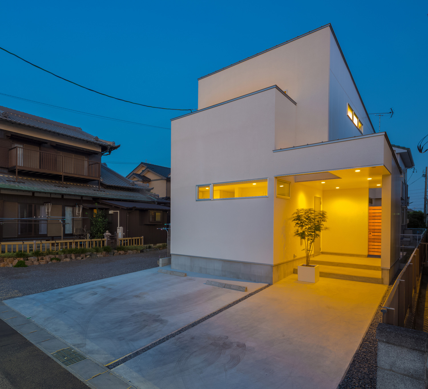 ダウンライト付きの軒天井がある玄関ポーチがあるスクエアな外観の家・デザイン住宅