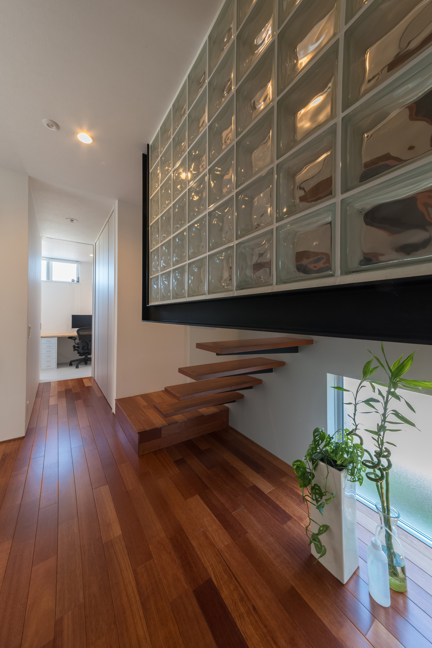 浮いたデザインの木の階段があるシンプルでおしゃれな廊下・デザイン住宅