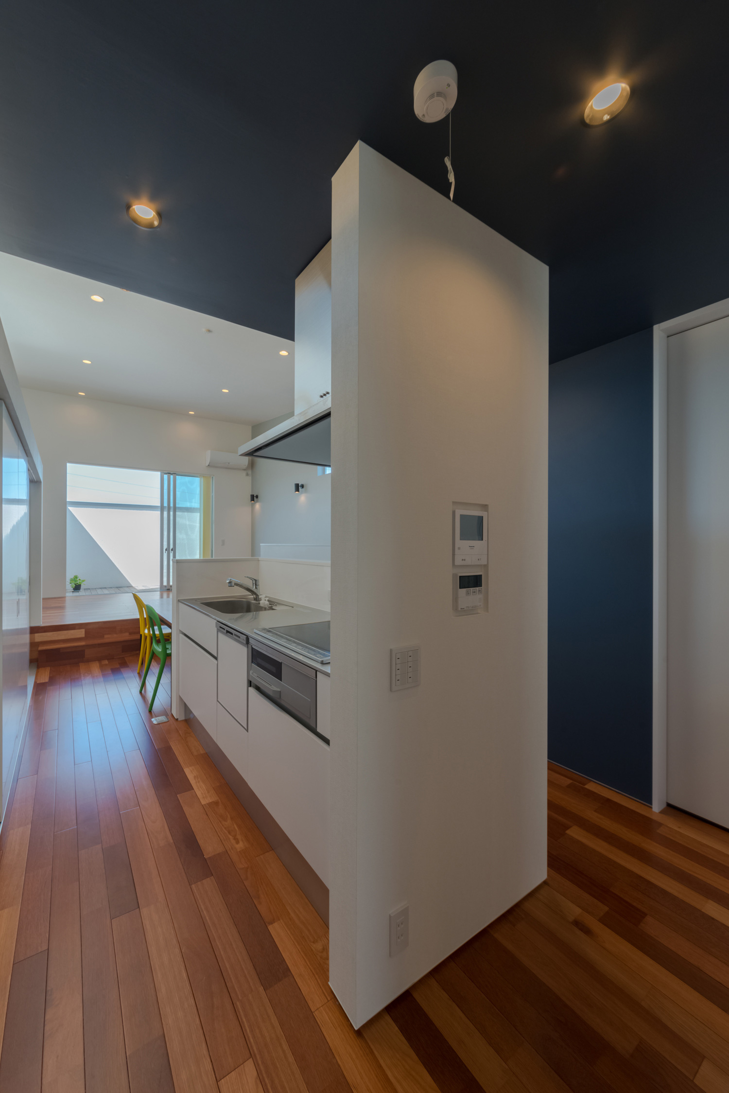 壁で仕切られたダイニングテーブルと横並びになったキッチン・デザイン住宅