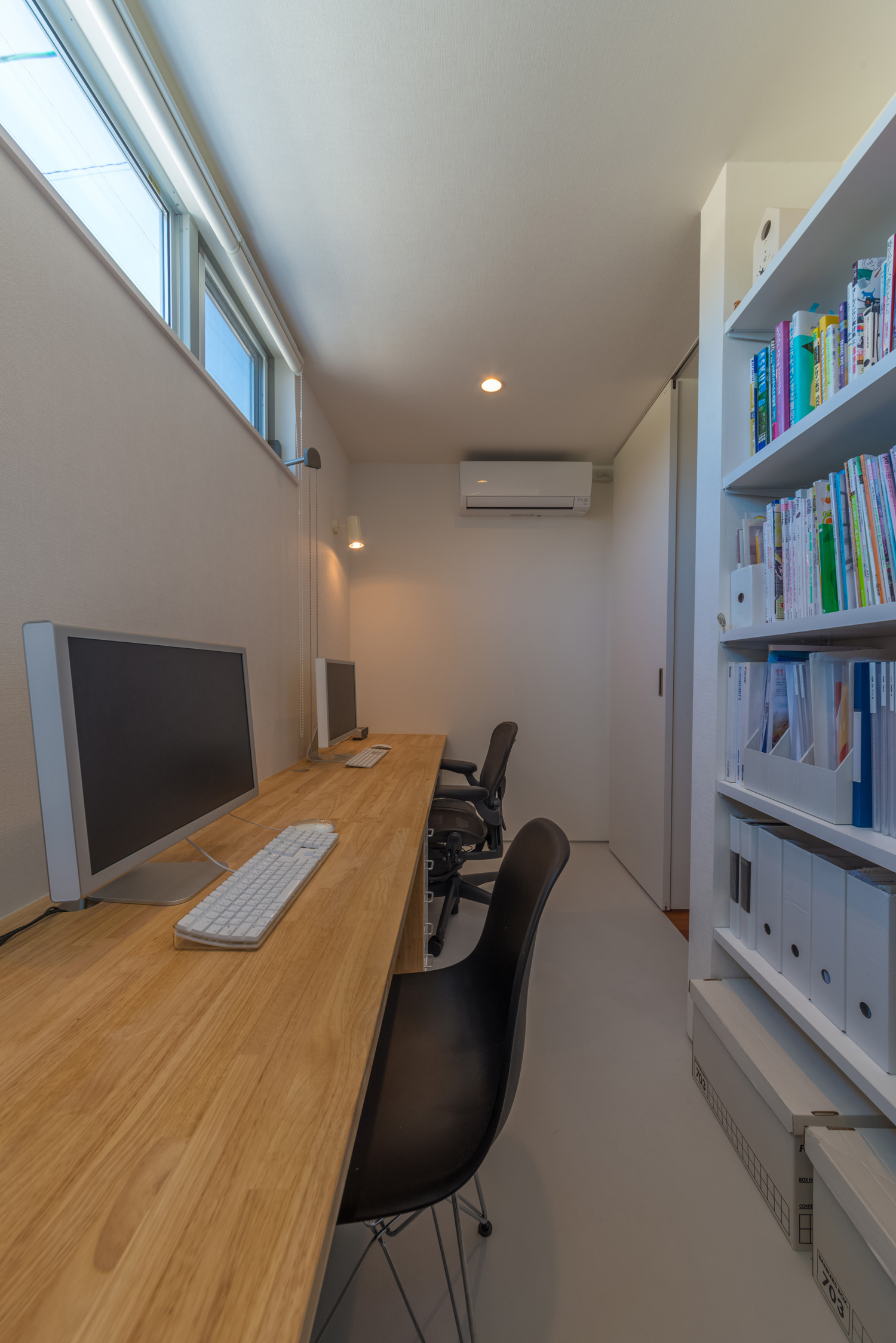 2人で並んで使うことが出来る壁付けデスクと本棚がある書斎・デザイン住宅