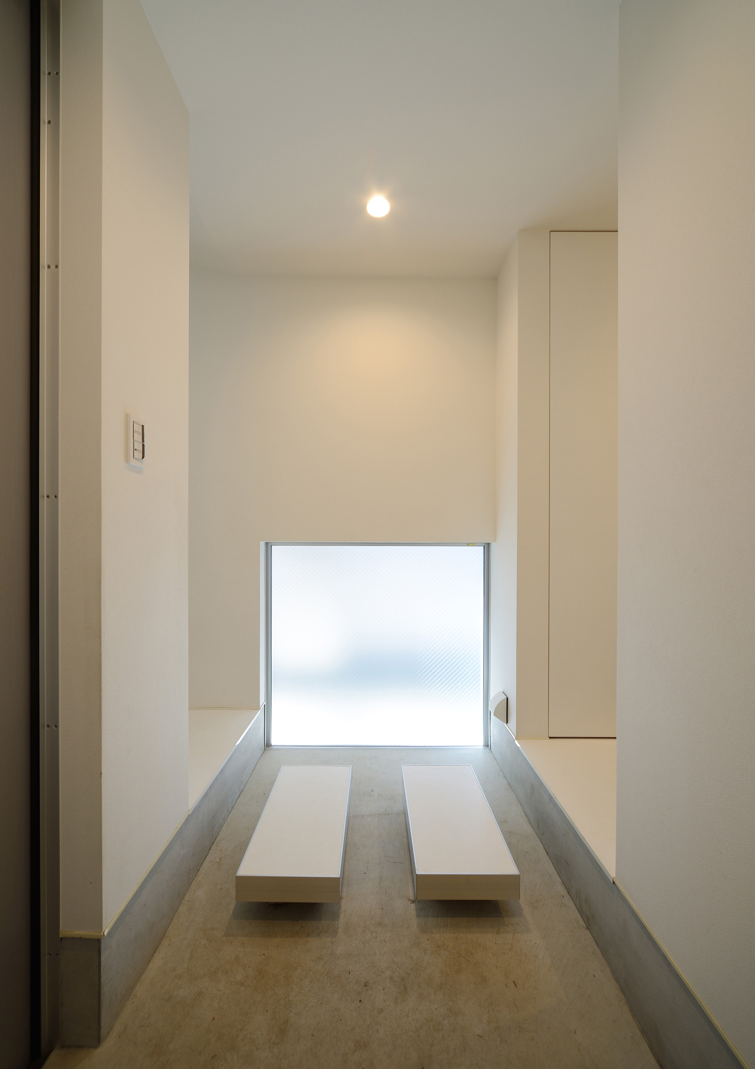 曇りガラスの地窓があるシンプルな土間玄関・デザイン住宅