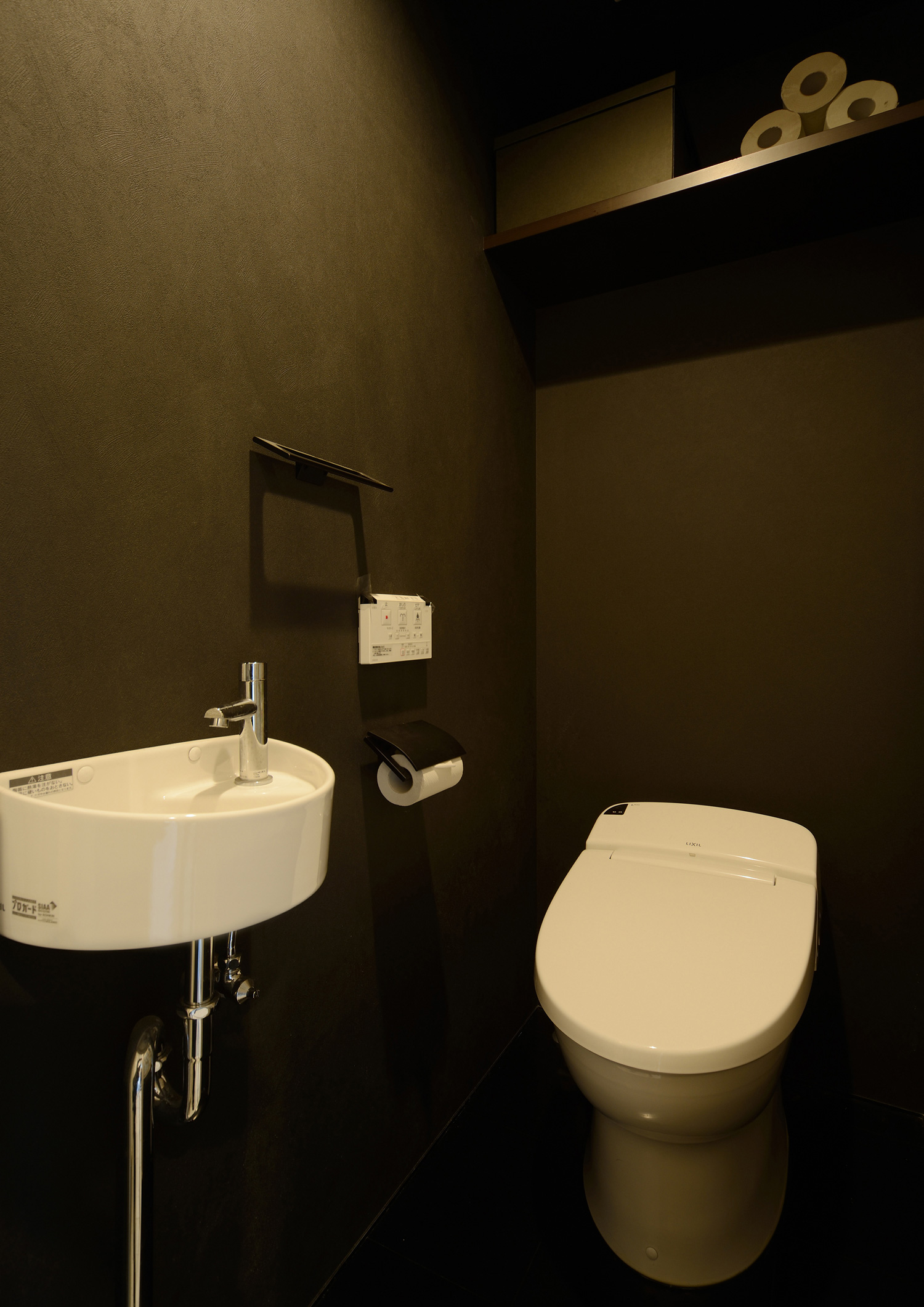 薄型手洗いがある黒いクロスの落ち着きのあるトイレ・デザイン住宅