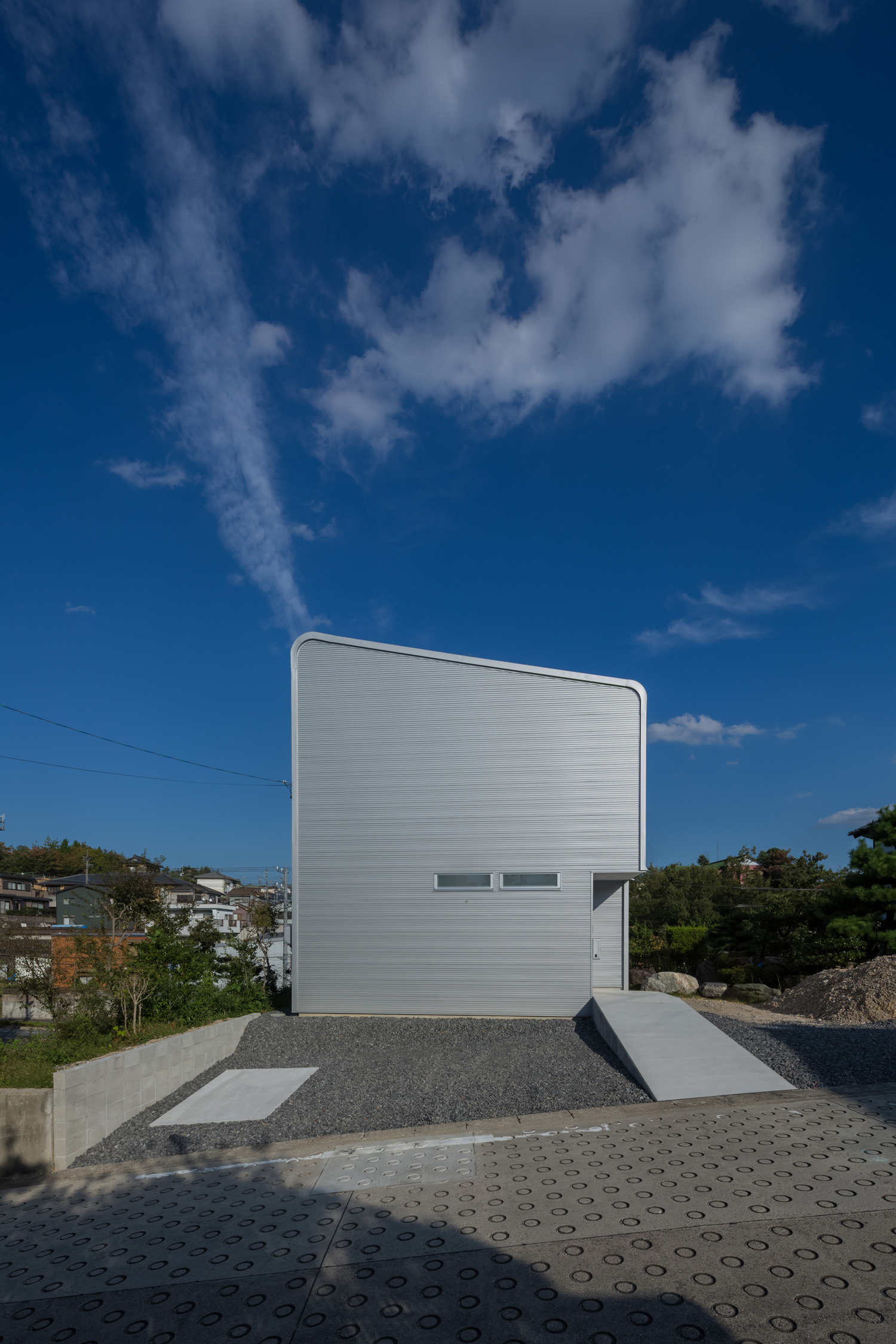 開けた土地に建つシルバーのガルバリウム鋼板の外壁の家・デザイン住宅