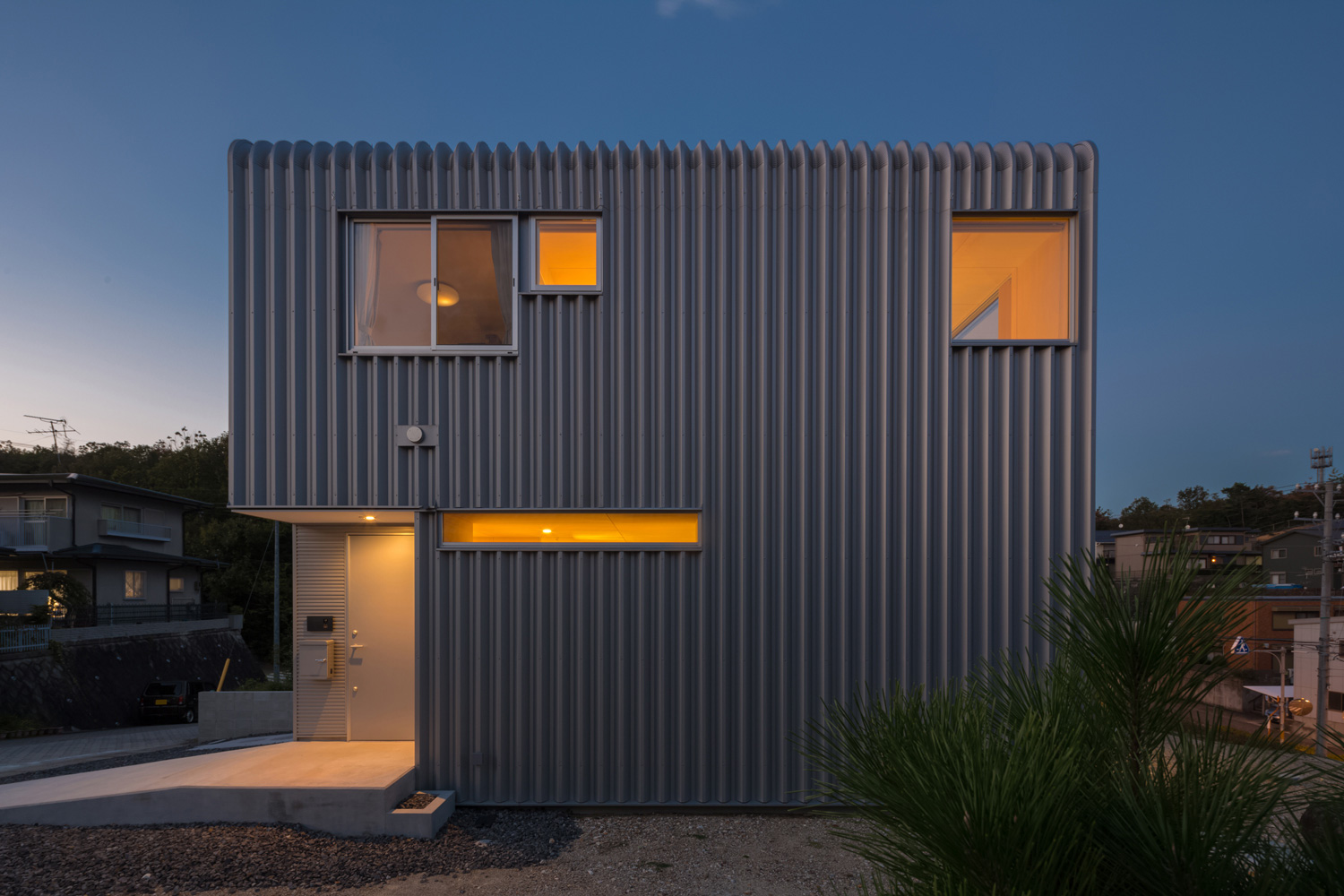 小さな窓やスリット窓があるスクエアな外観でシルバーの外壁の家・デザイン住宅