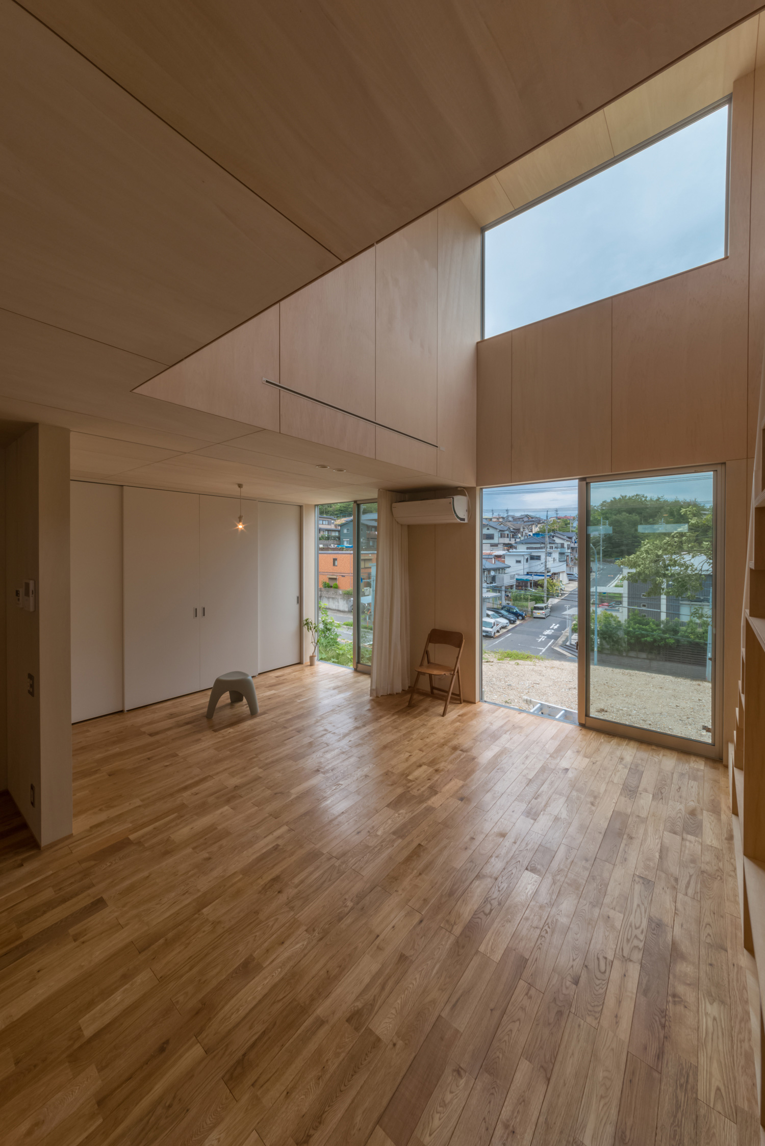 テラスに面した大きな窓と吹き抜けの上にある窓から光が入る明るいLDK・デザイン住宅