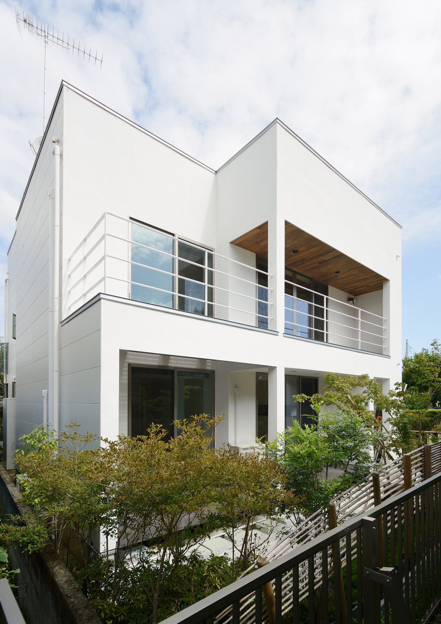 白いスクエアな外観でバルコニーがあるおしゃれな家・デザイン住宅