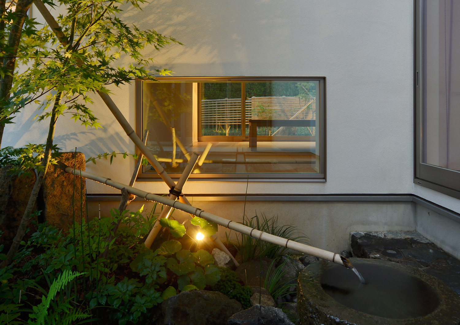 ライトアップされた植栽がある中庭に面した地窓・デザイン住宅