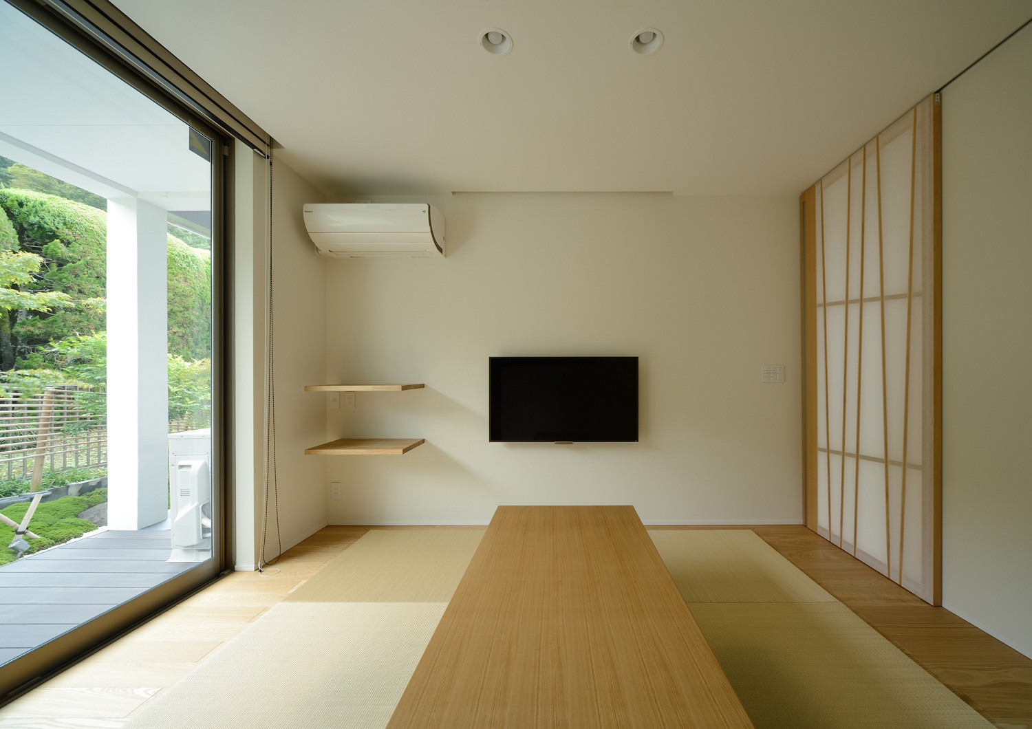 壁かけのテレビがある、縁側に面した窓がある和室・デザイン住宅