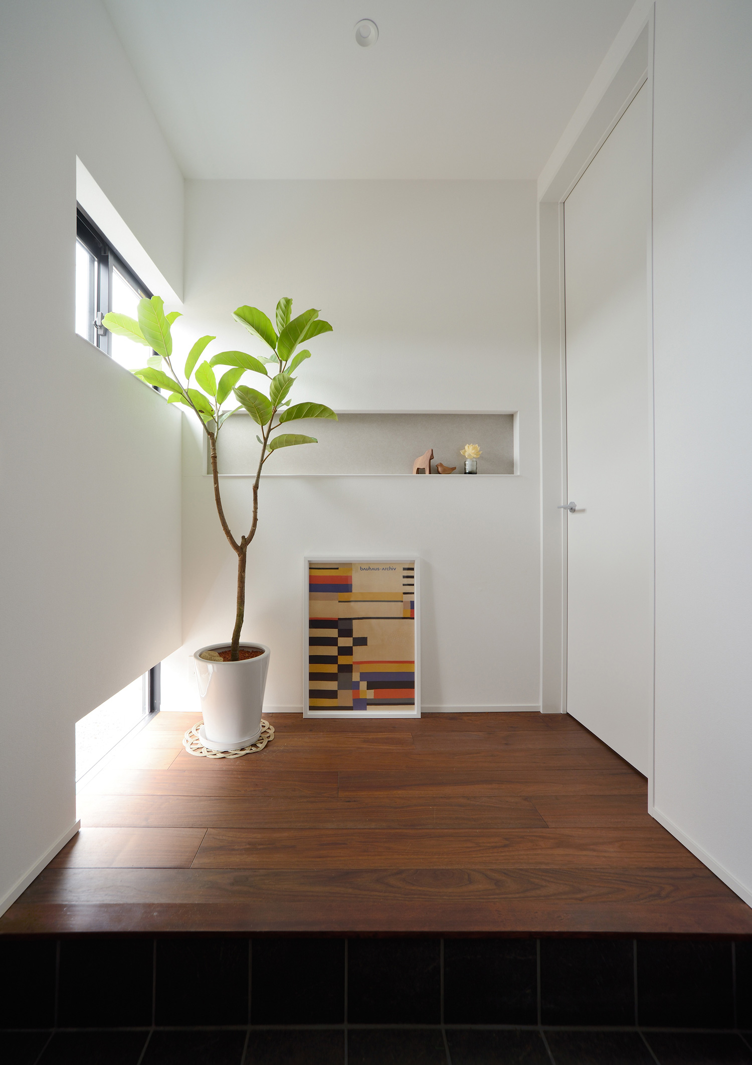 スリット窓と地窓から光が入るシンプルでナチュラルな玄関・デザイン住宅