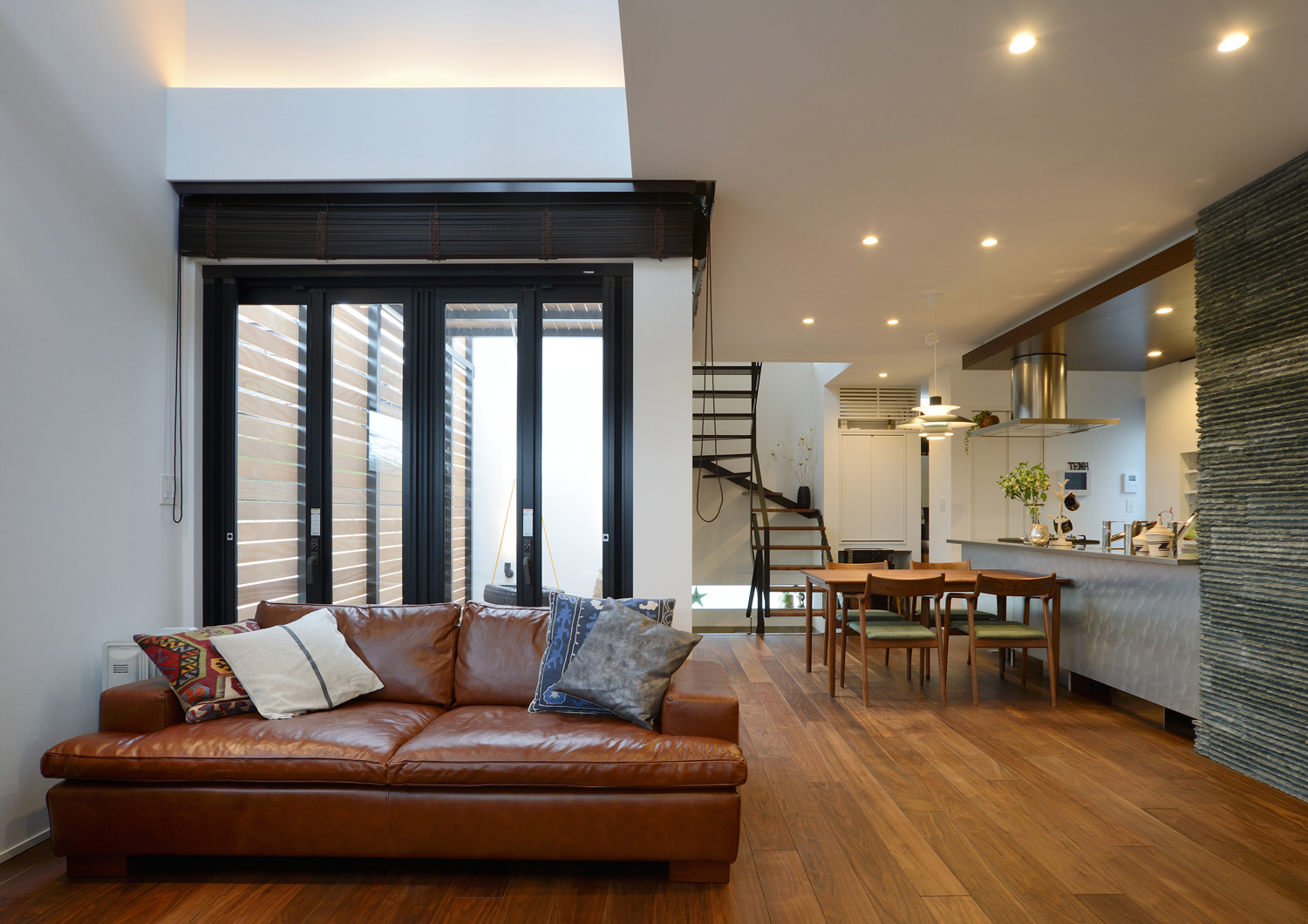 吹き抜けの壁際にライン状の間接照明を取り付けたシンプルで開放的なLDK・デザイン住宅