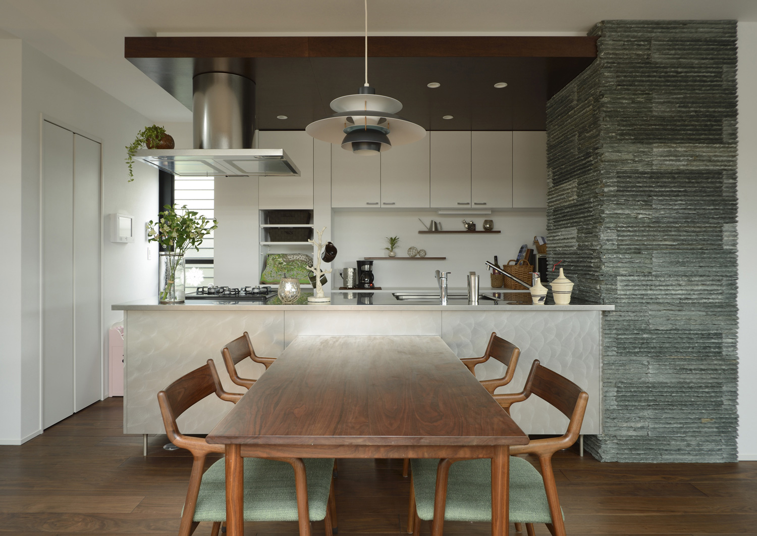 タイル貼りの壁に付けられたシンプルでおしゃれなペニンシュラキッチン・デザイン住宅