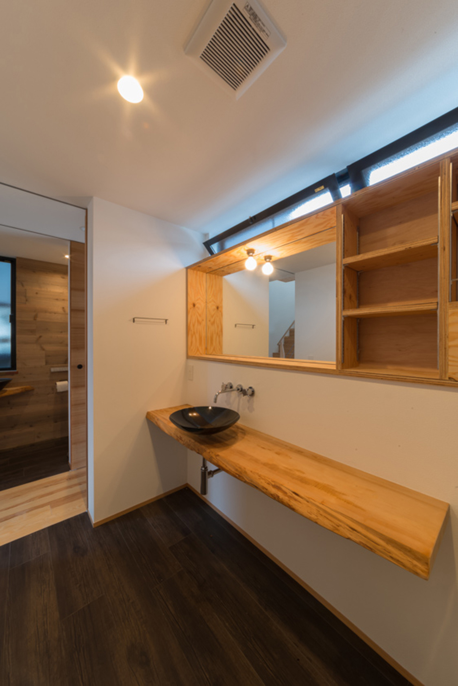 木の洗面台と木の収納棚があるシンプルでナチュラルな洗面所・デザイン住宅