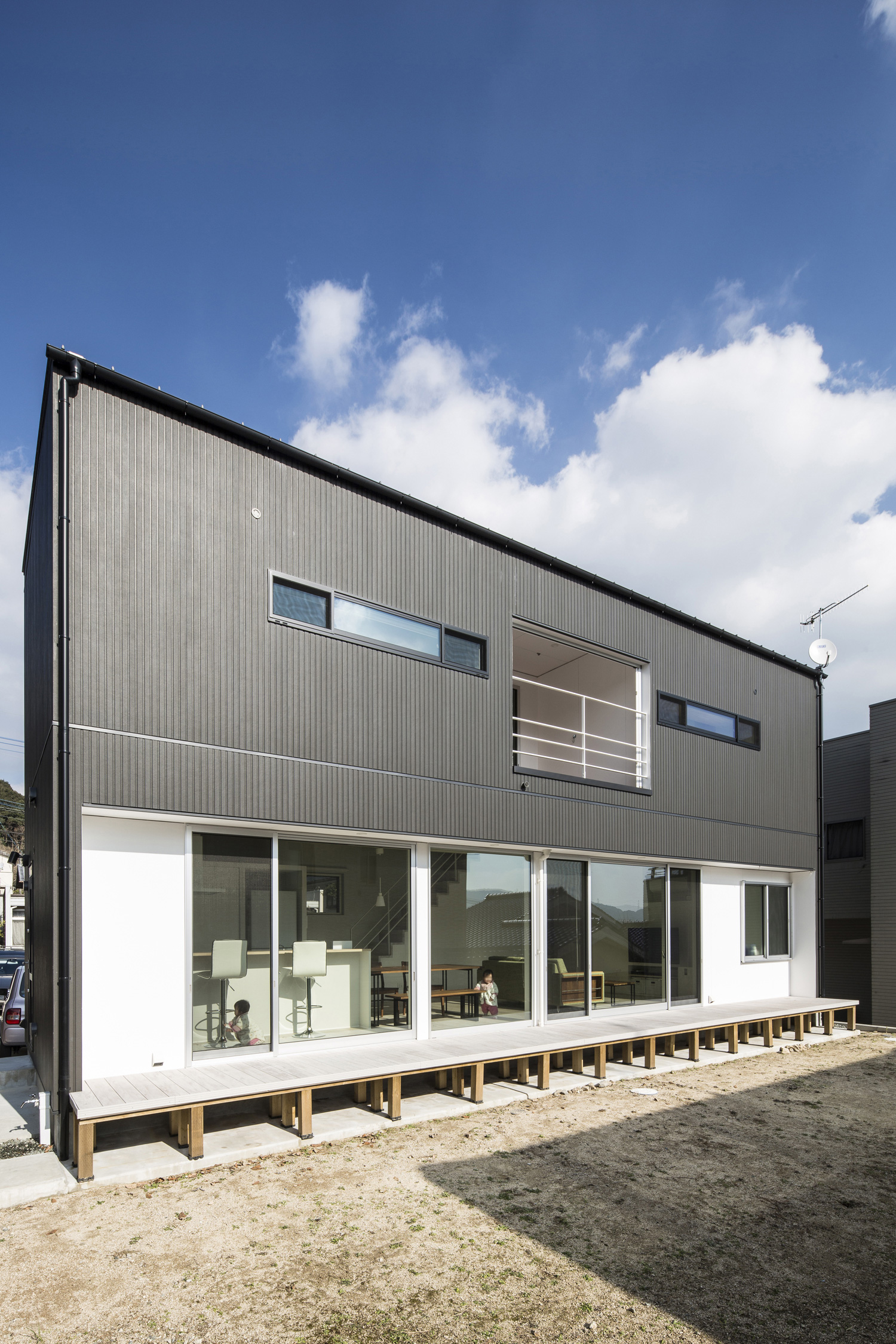 庭に面した大きな窓があるモノトーンの外壁の家・デザイン住宅