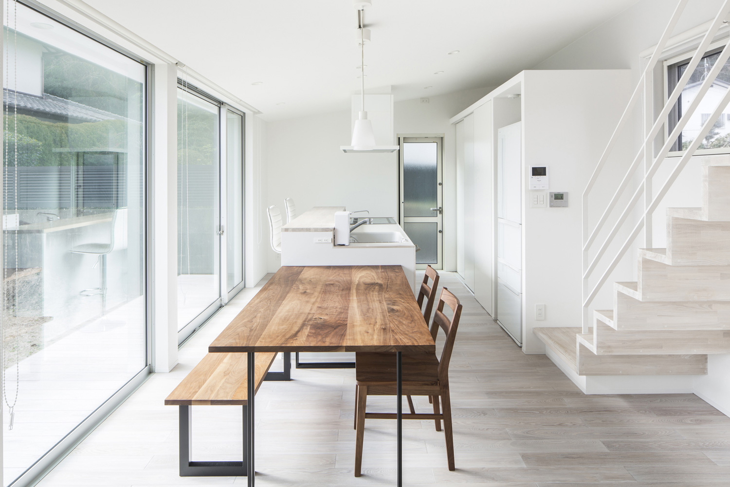 白を中心とした空間に木の一枚板のダイニングテーブルがアクセントになったLDK・デザイン住宅