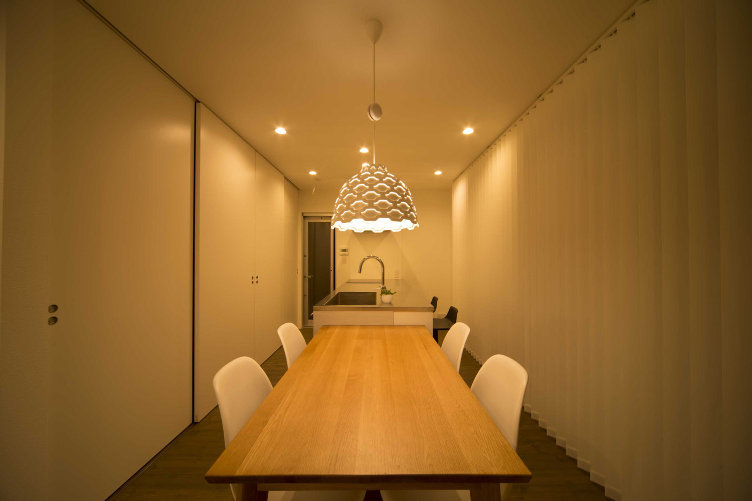 おしゃれなペンダントライトがアクセントになった木製のダイニングテーブルとアイランドキッチンがあるLDK・デザイン住宅