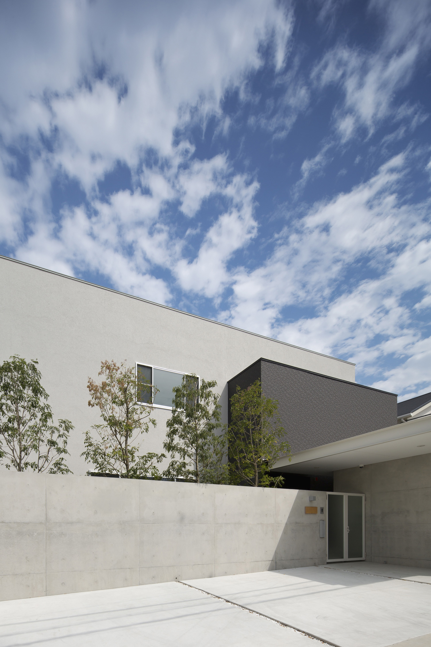 コンクリートの塀を取り付けた重厚感のあるキューブ状の外観の家・デザイン住宅