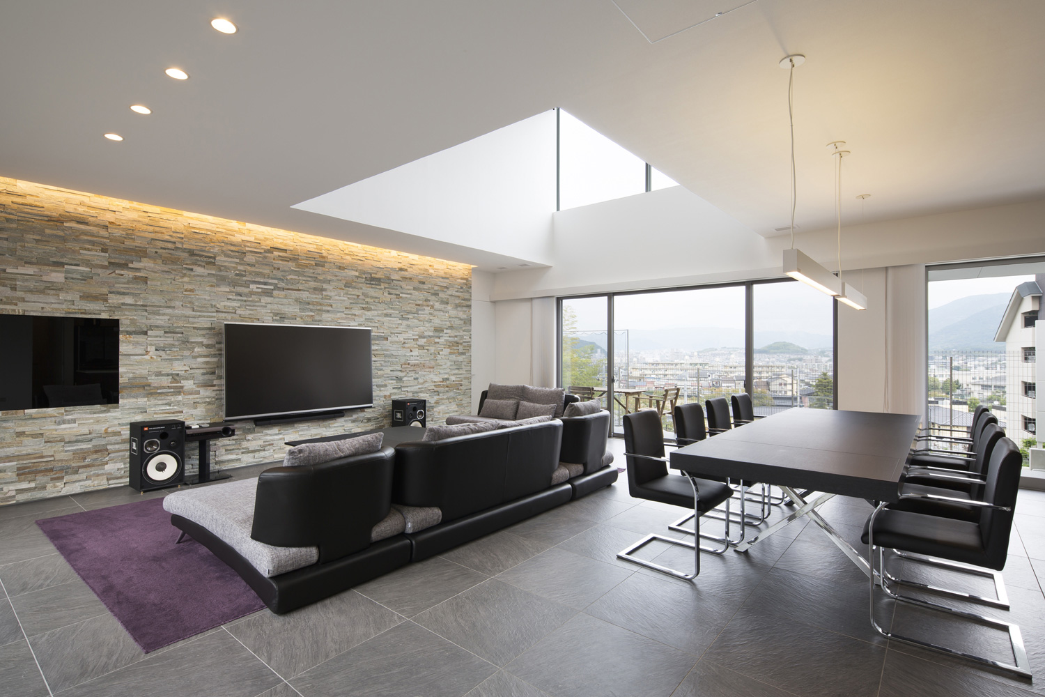 中央に吹き抜けがあり壁一面に大きな窓がある開放的なLDK・デザイン住宅