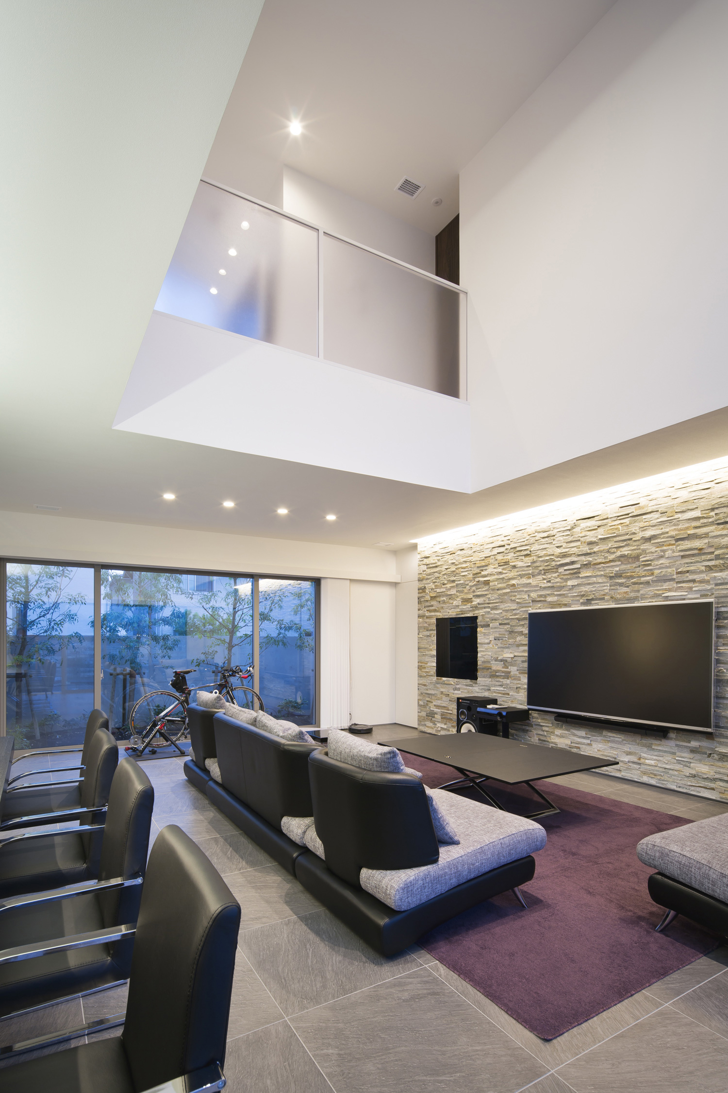 タイルのアクセントウォールに間接照明が取り付けられたホテルライクなLDK・デザイン住宅