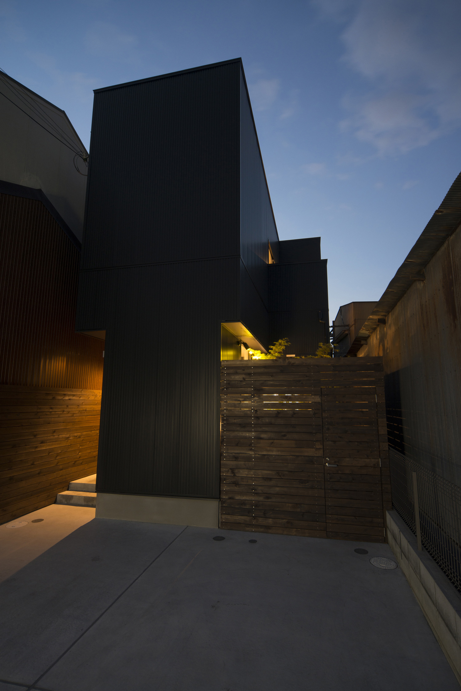 木の目隠しから中庭の光が漏れるシンプルな外観の家・デザイン住宅