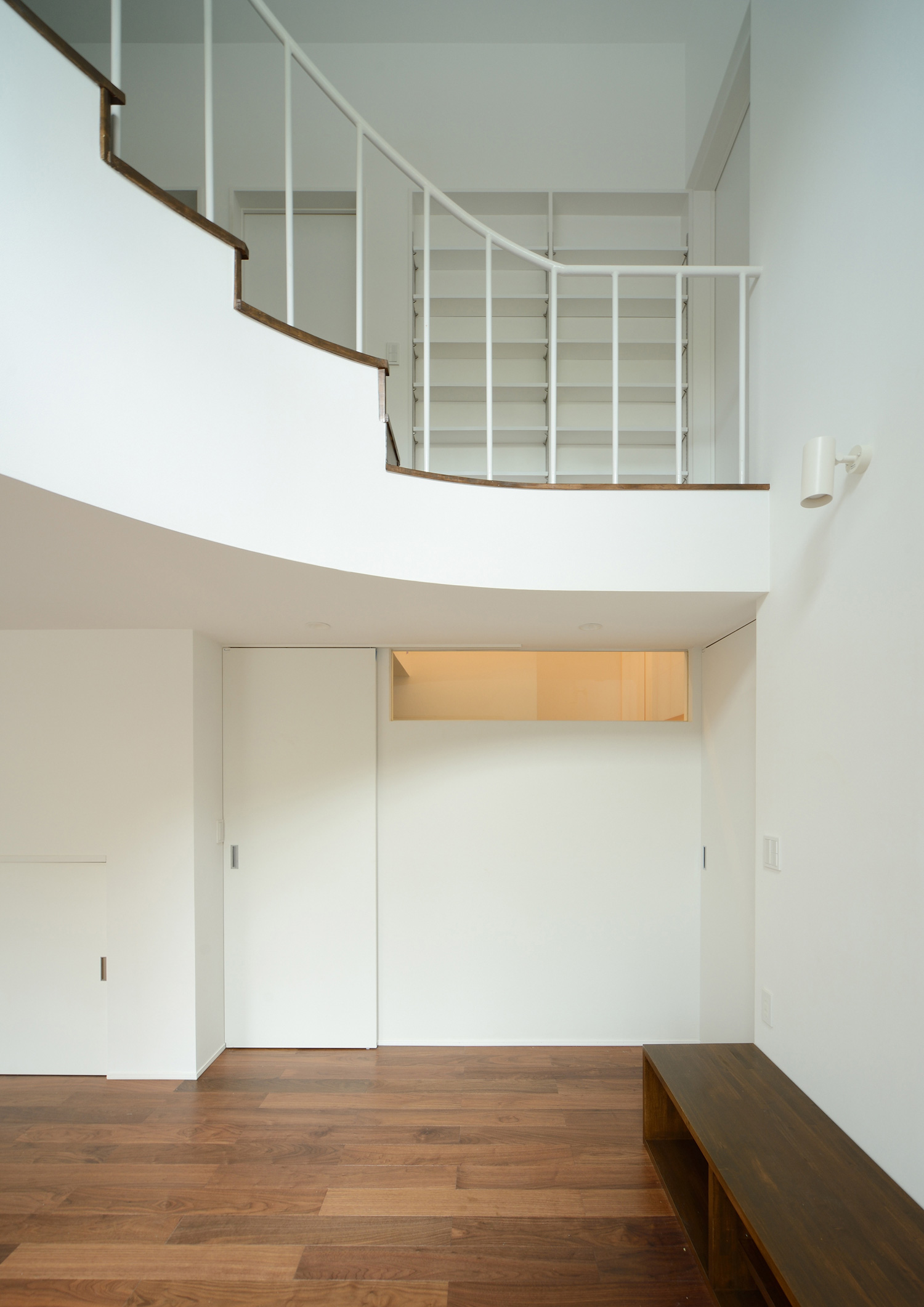 吹き抜けに面したR階段があるLDK・デザイン住宅