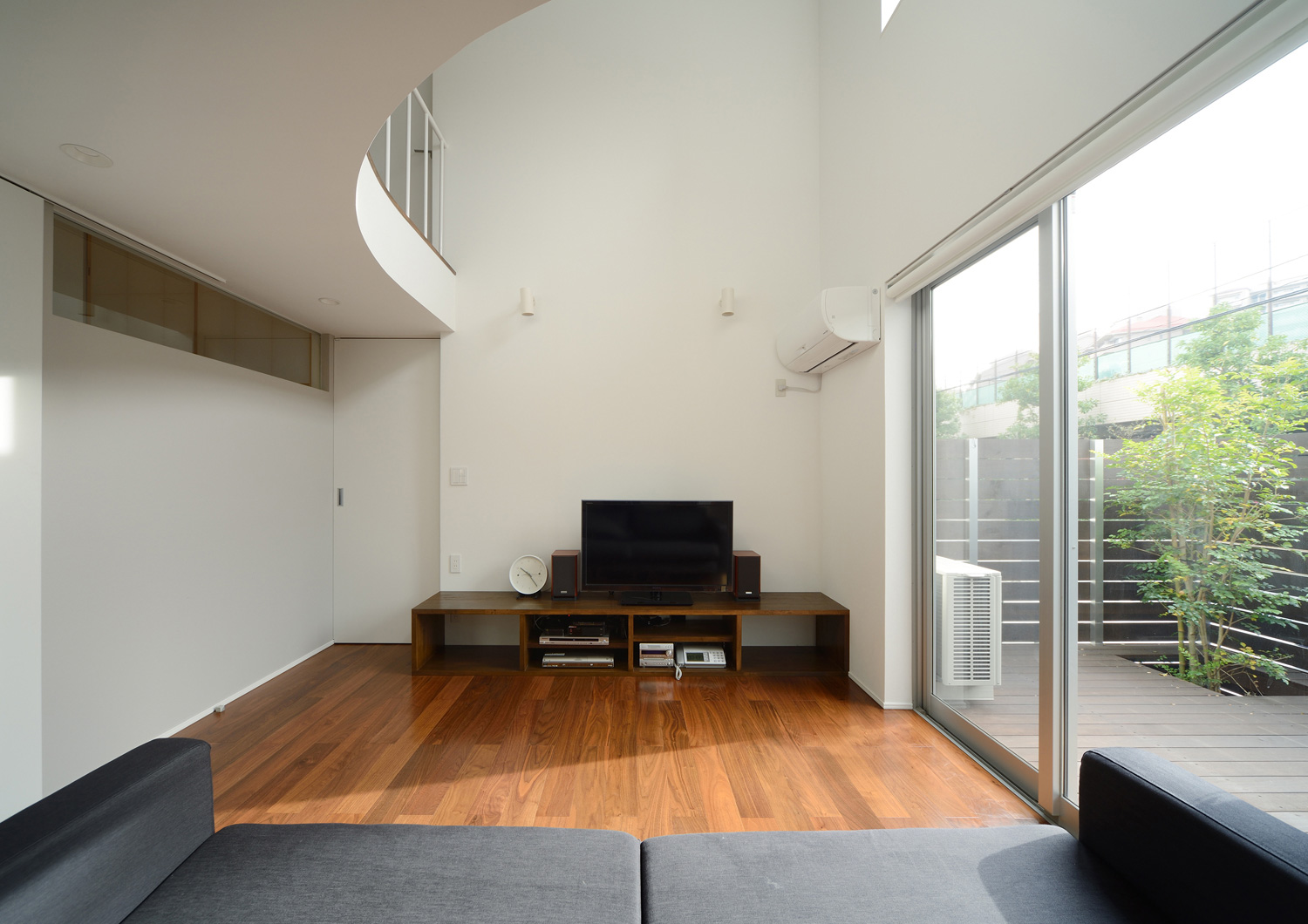 テラスに面した大きな窓がある吹き抜けのLDK・デザイン住宅