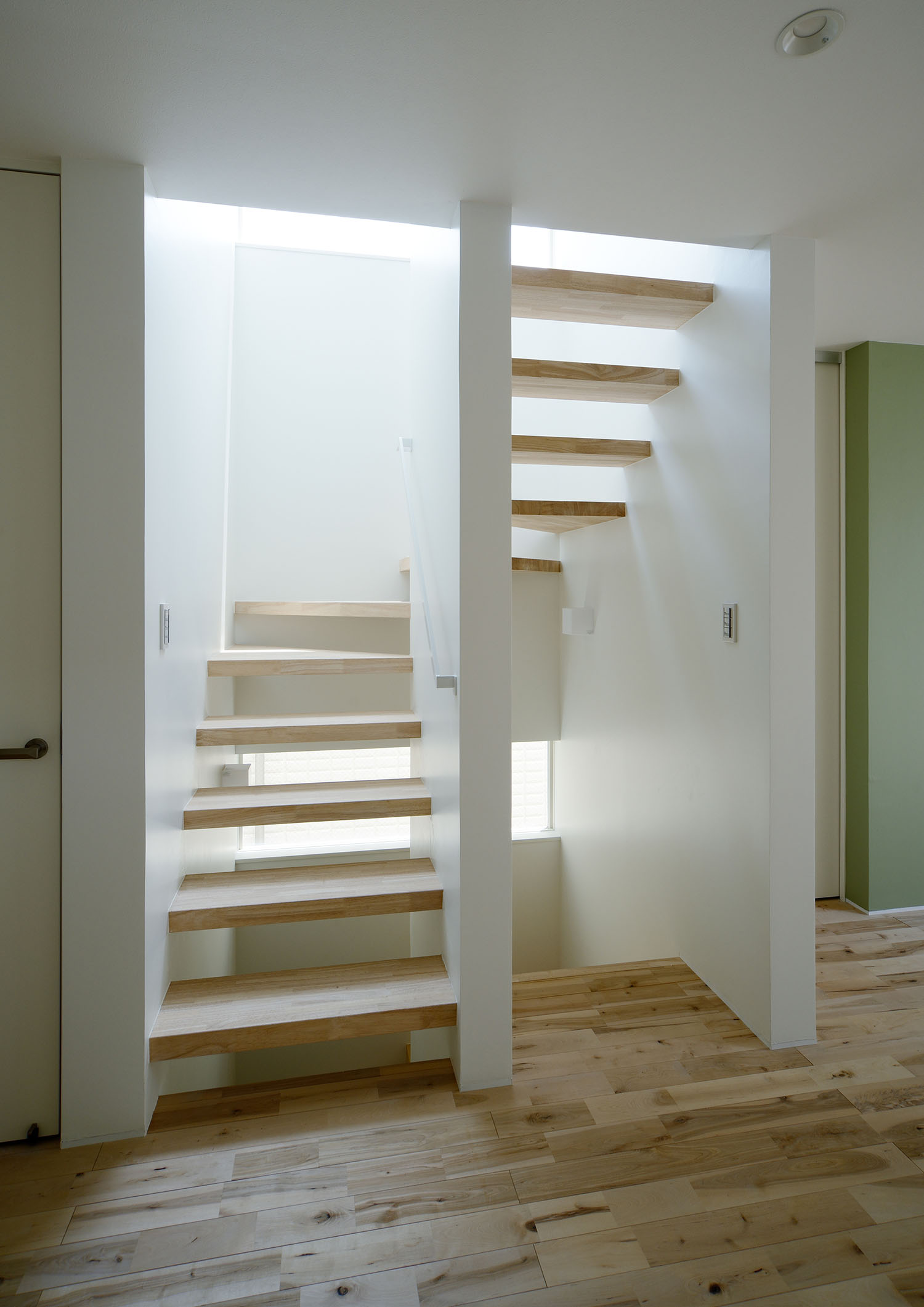 スリット窓から光が入る明るいスケルトン階段の階段室・デザイン住宅