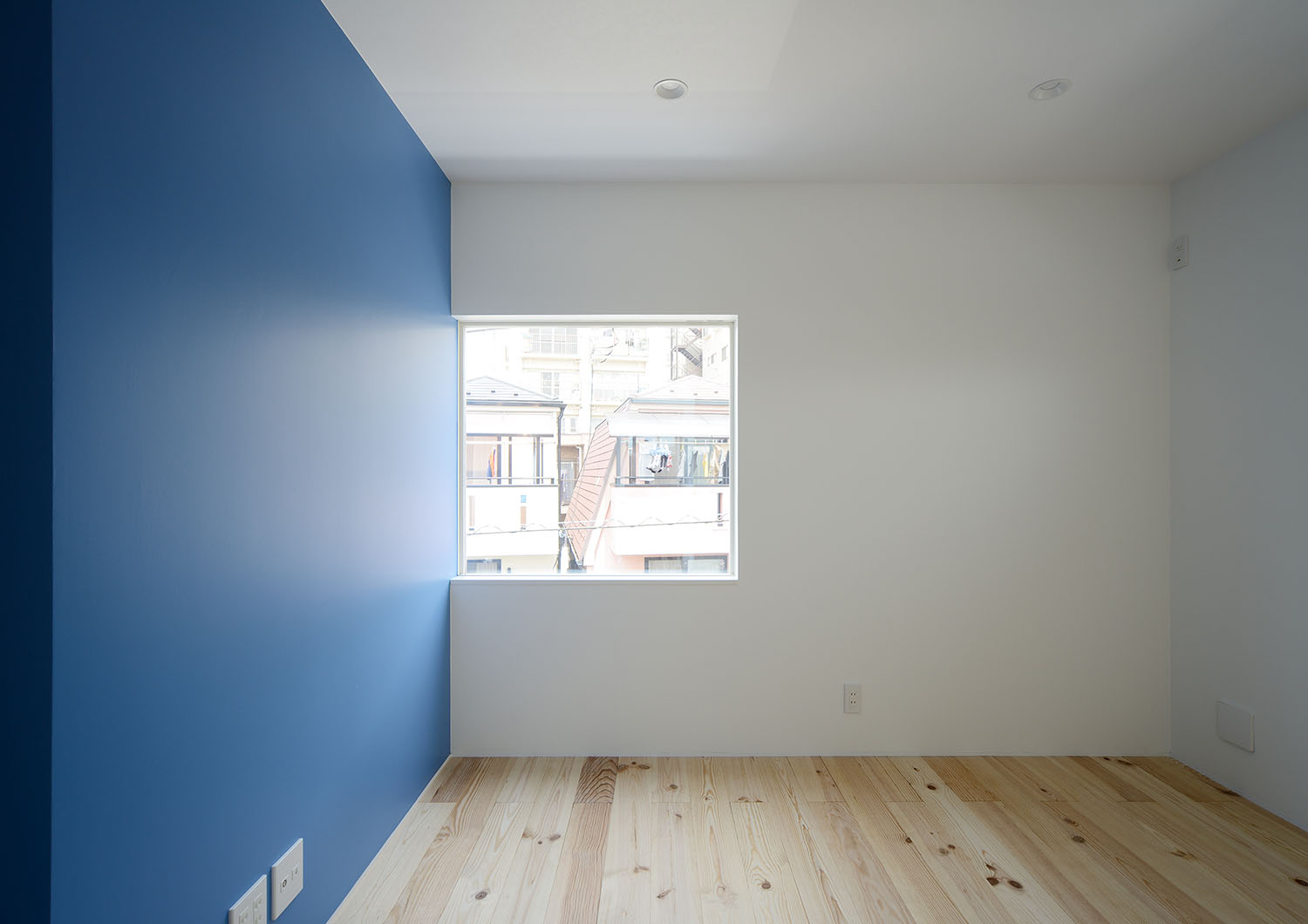 正方形の窓と青いアクセントウォールがある子供部屋・デザイン住宅