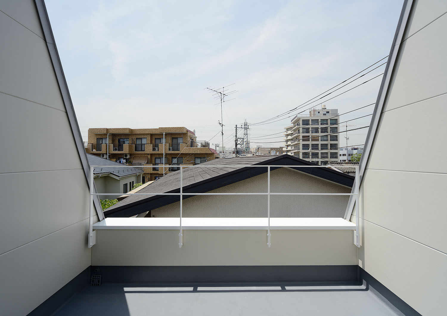 白いアイアンの手すりが取り付けられた開放的なバルコニー・デザイン住宅