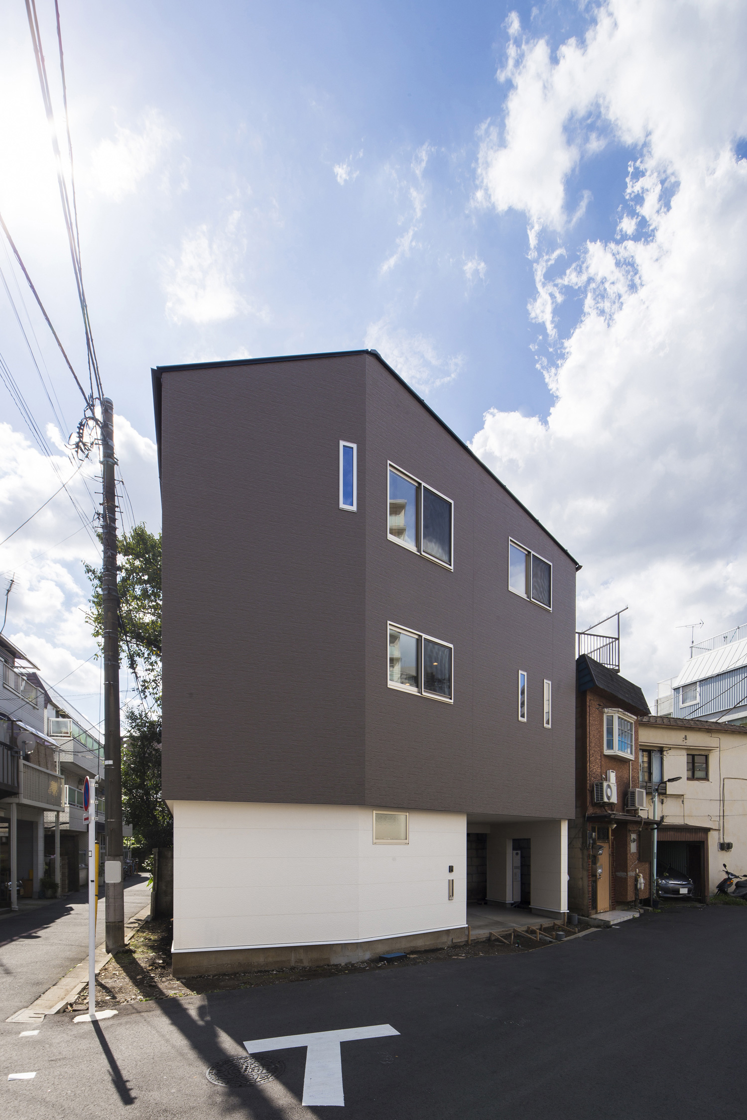 白とグレーの外壁のシンプルな三階建ての家・デザイン住宅