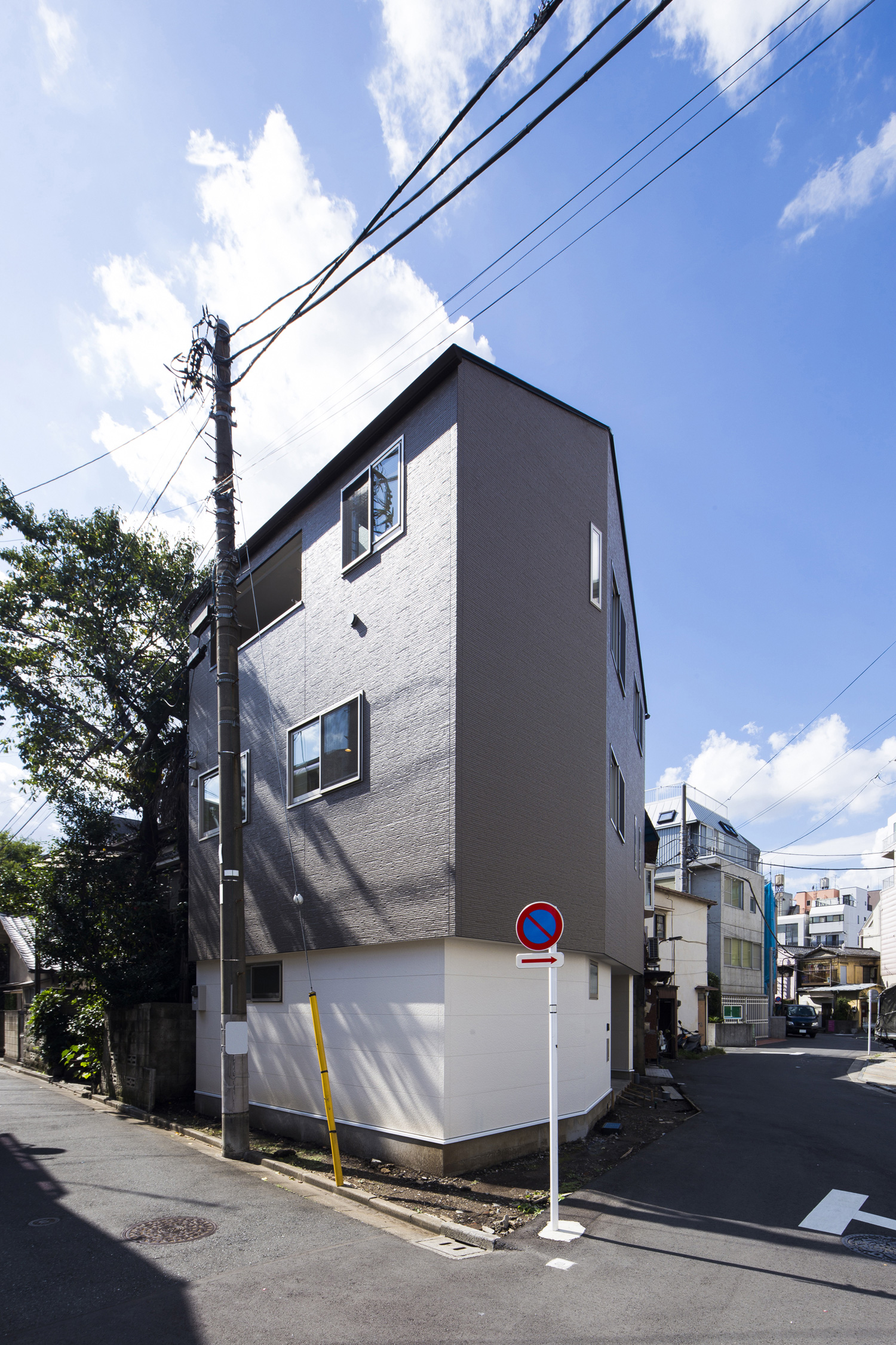 角地に建つグレーの外壁の三階建て住宅・デザイン住宅