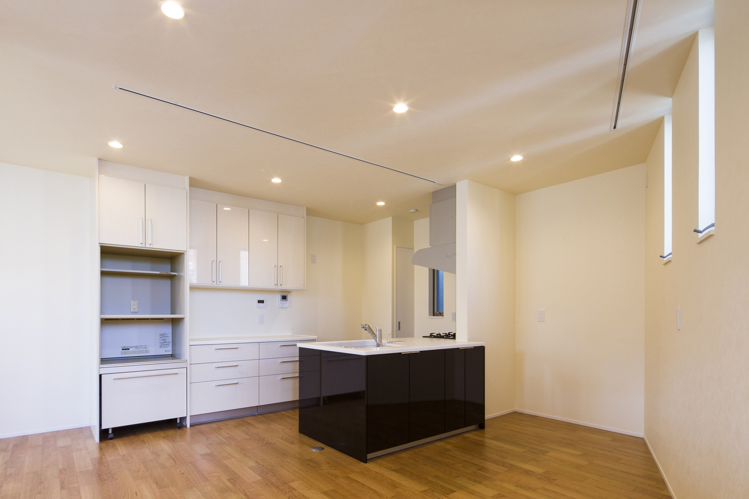 黒いペニンシュラキッチンがあるフローリングのLDK・デザイン住宅