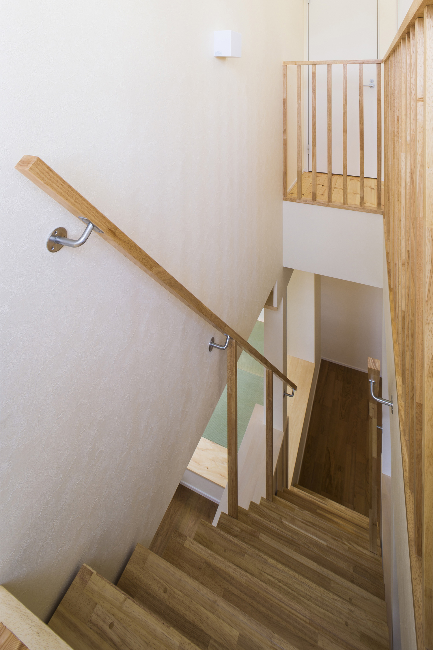 木の手すりや柵が取り付けられた木製のスケルトン階段・デザイン住宅