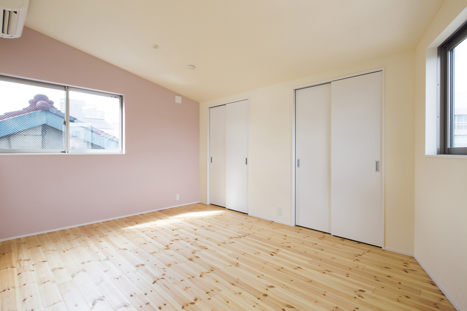 ピンクのアクセントクロスがある母屋下がりの寝室・デザイン住宅