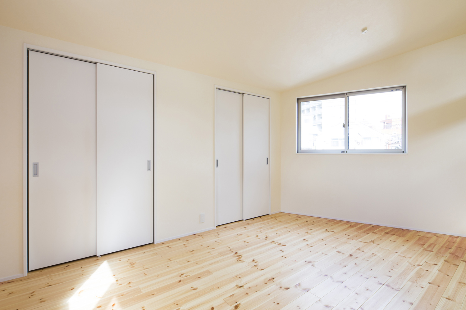 扉付きのクローゼットが取り付けられた左右対称の寝室・デザイン住宅